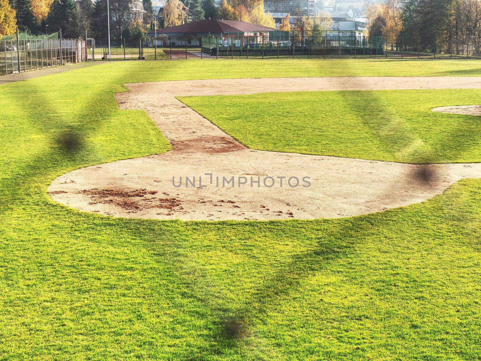 Baseball stadium. Green grass on baseball field  behind of safety net.