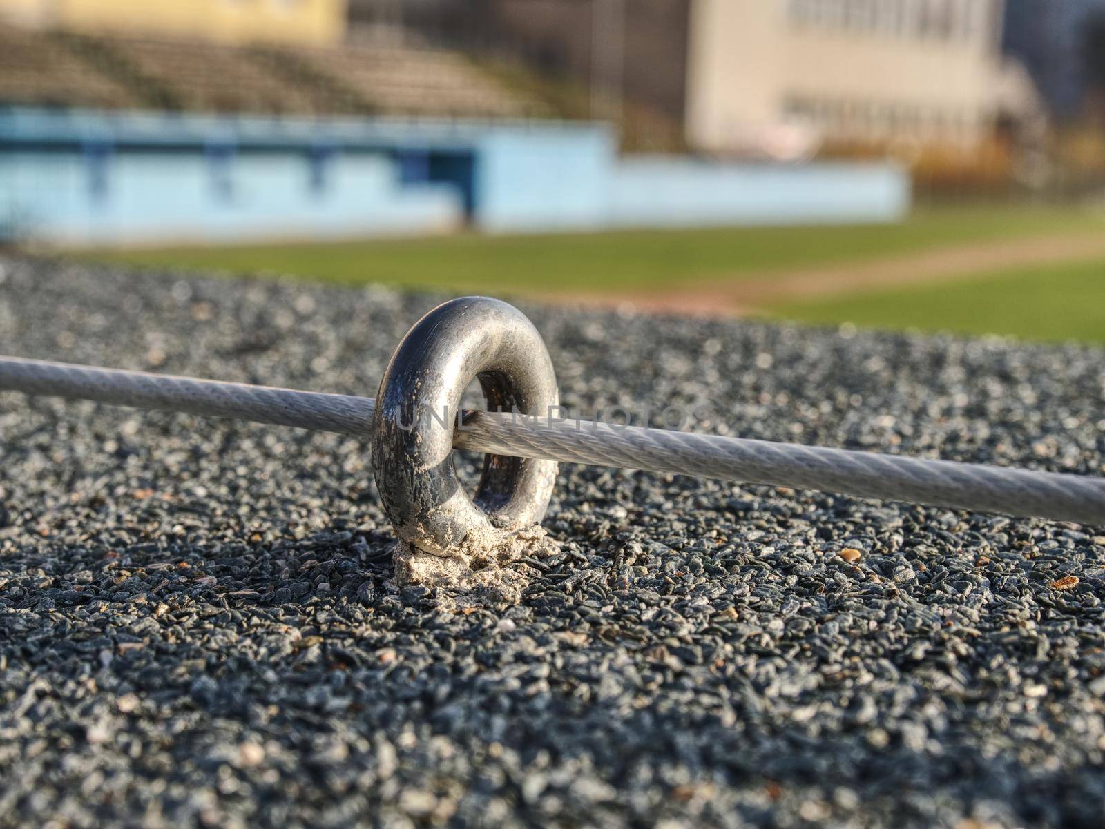 Steel twisted rope and steel bolt anchor eye in concrete base. The end knot of steel rope. 