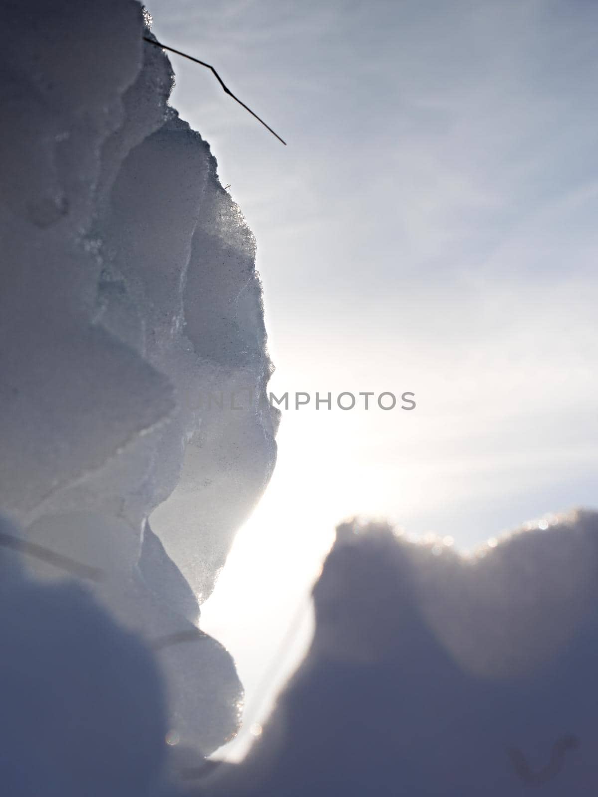 Dark ice hole with sun flares. Nature art with small depth of field. Amazing natural background