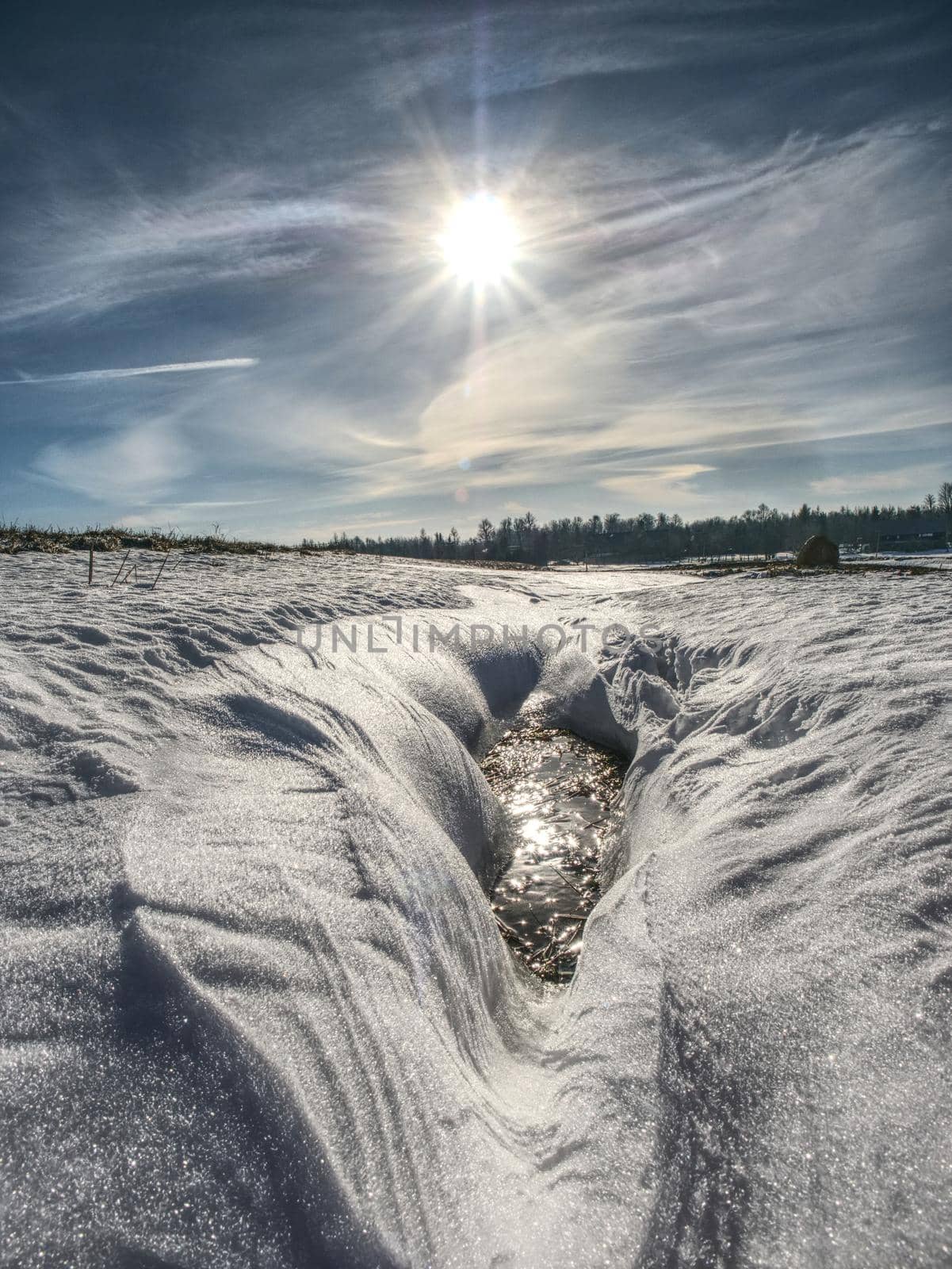 Hole in icy snow with sun flares. Lovely winter  by rdonar2