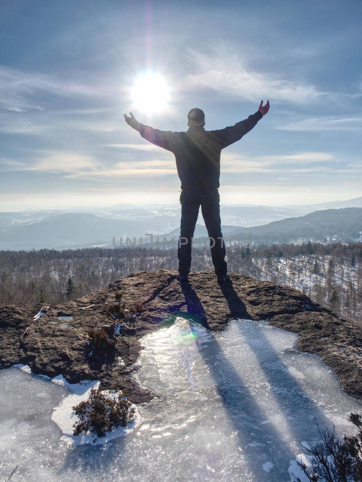 Standing man with raised arm on icy stone  by rdonar2