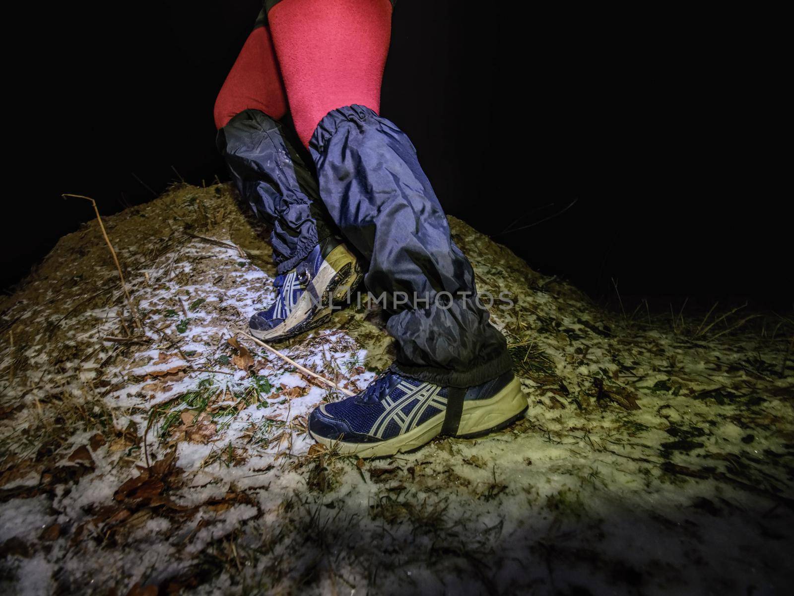 Winter night extreme runner control map.  January 25th 2019, Novy Bor, Czech Republic. Girl in forest reading map and checking a control point. Selective focus