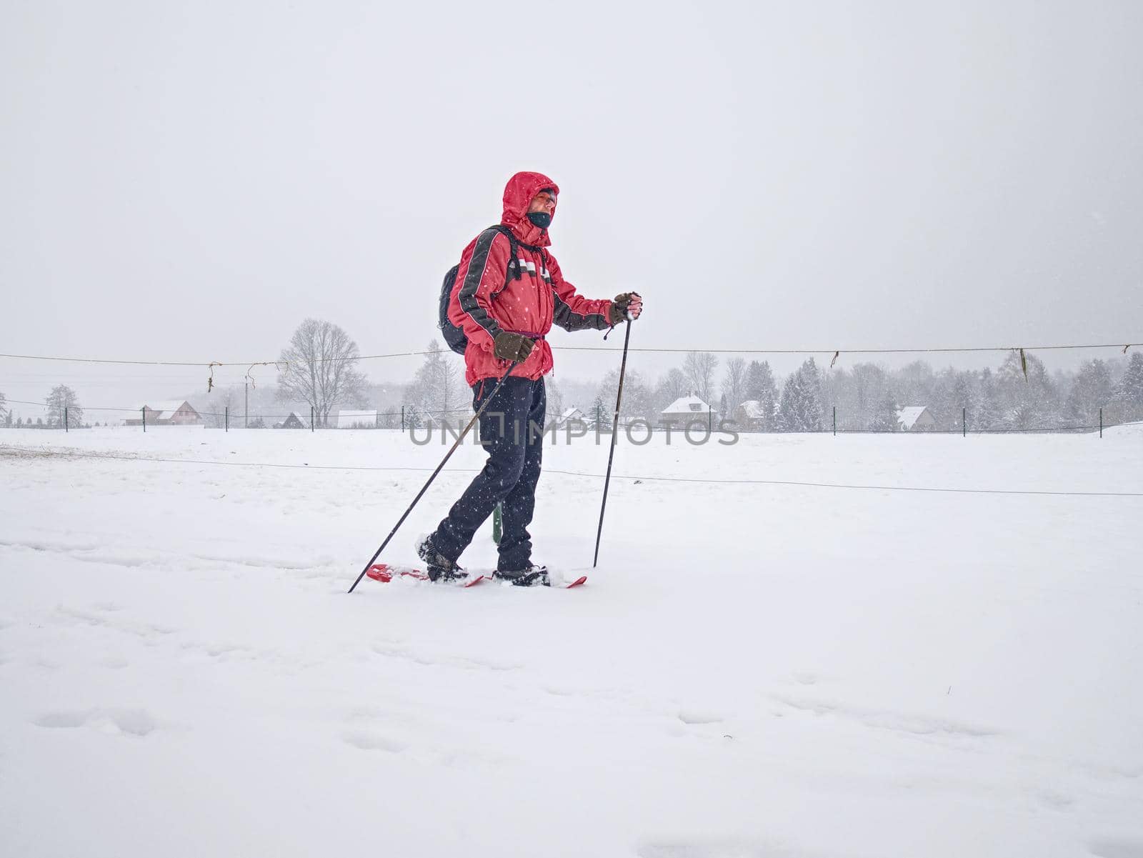 Hiker with snowshoes and technical outdoor clothing for mountain walks in snow