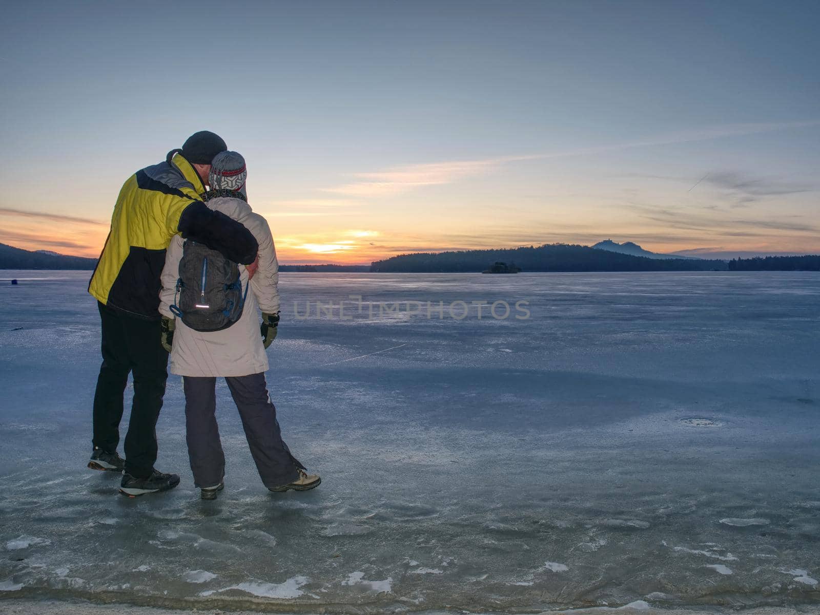 Greenland hiking travel tourist lovers with hold hands at icebergs and frozen ice floating in ocean sea. Arctic nature landscape. Adventure in the outdoors.