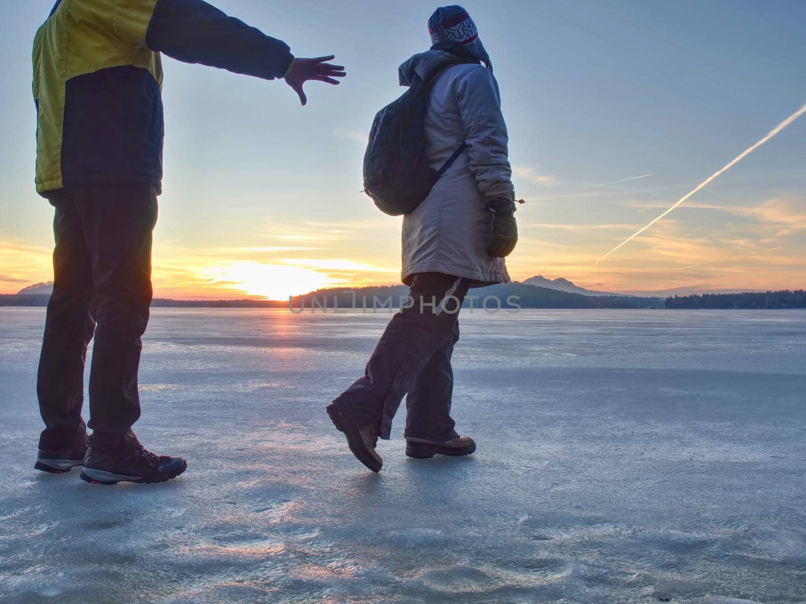 Cute couple in bay of frozen sea. They hold together at pond by rdonar2