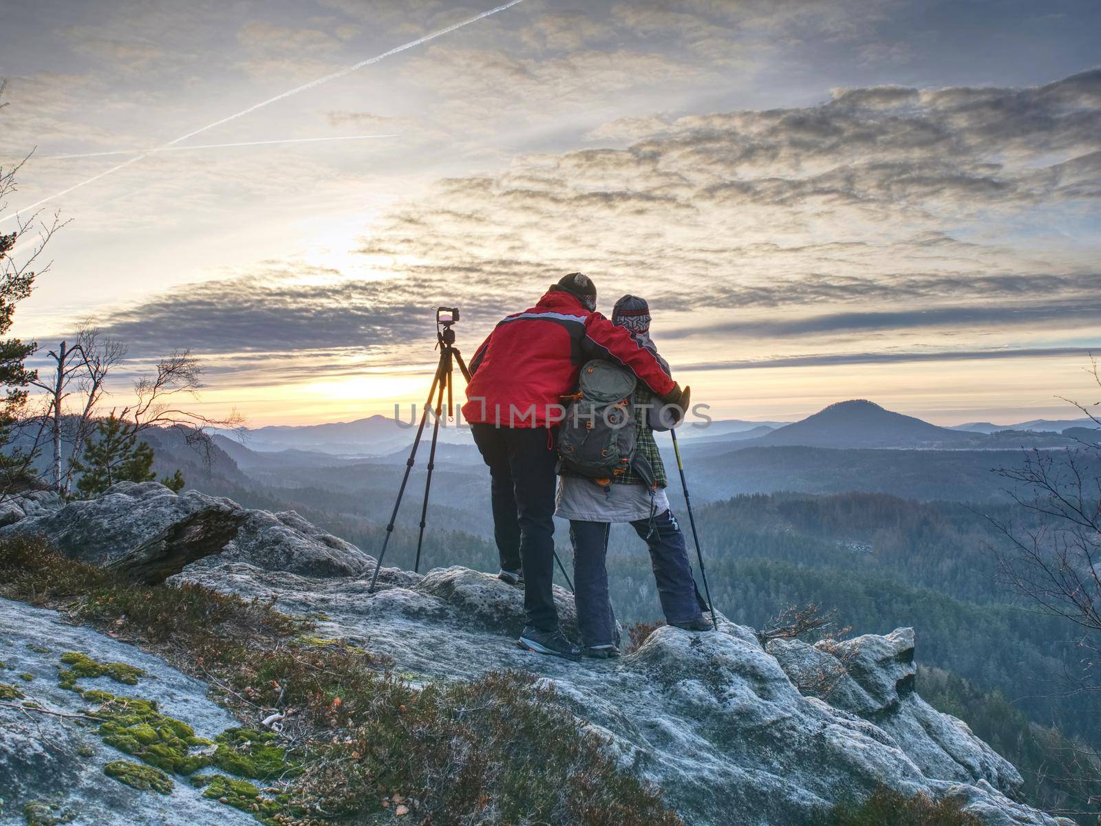 Two wildlife photographers at tripod with set  shinning camera enjoy autumn morning in wildnature