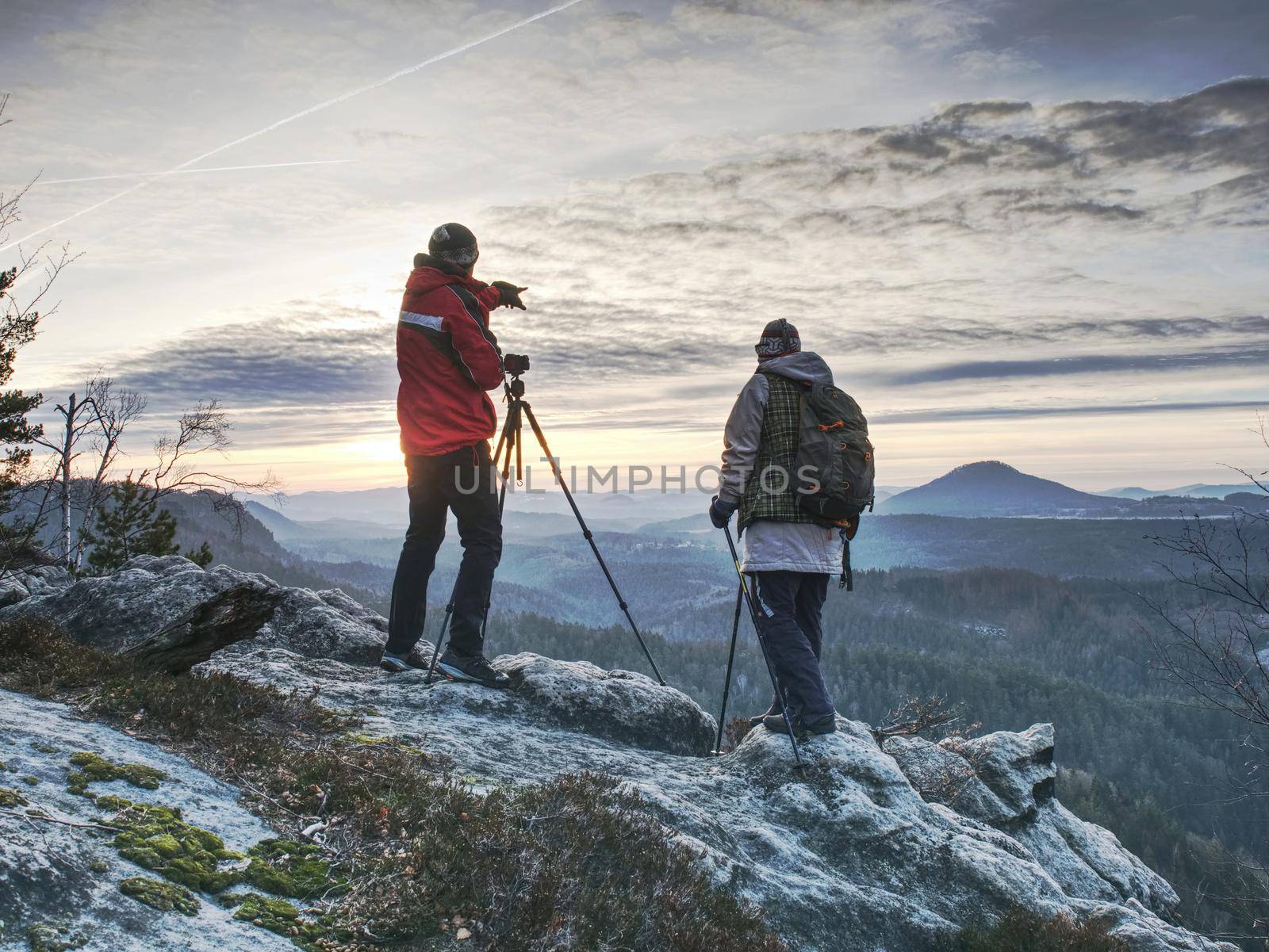 Couple hiking photographers on view point above forest by rdonar2