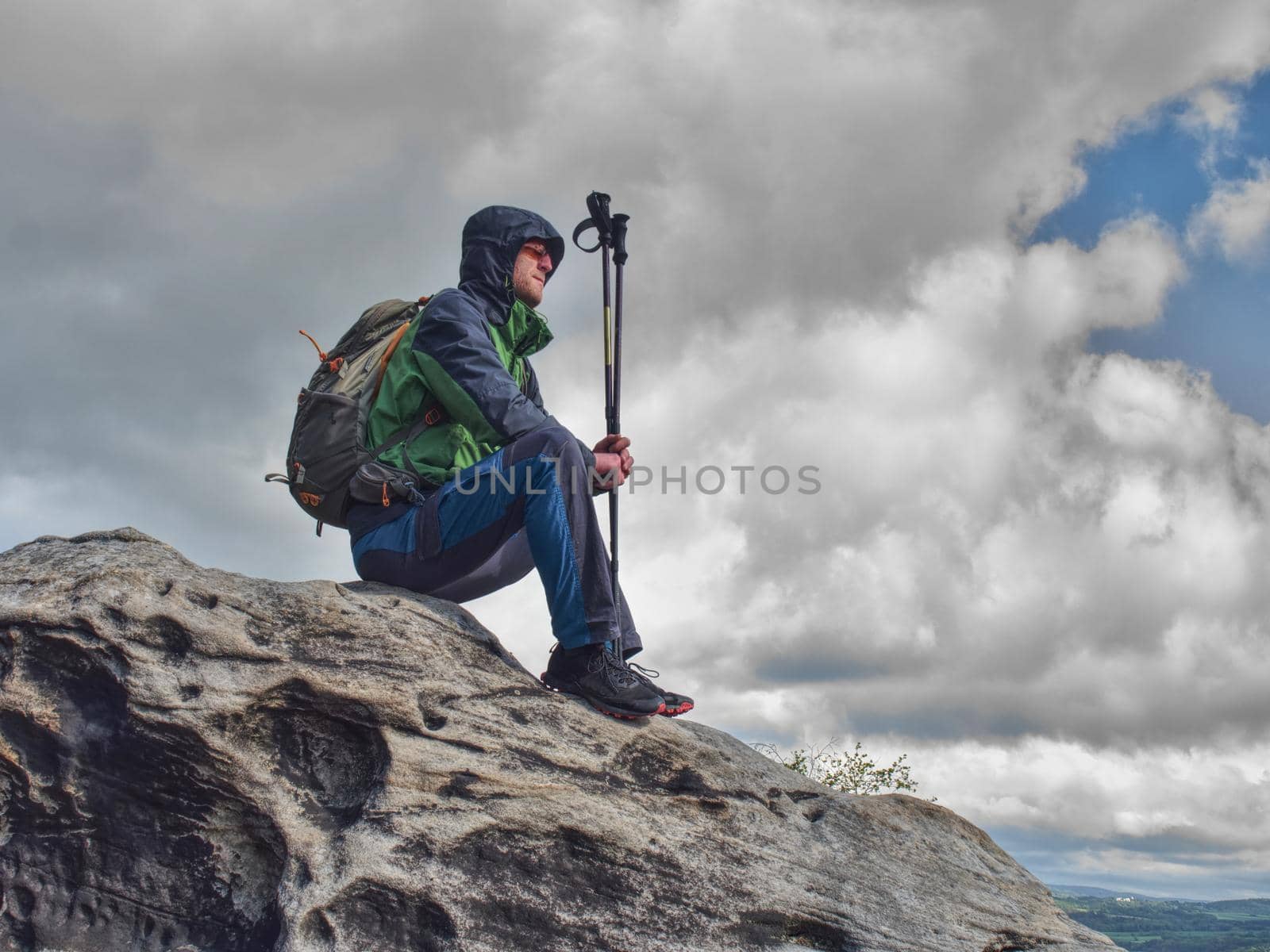 Tired man hiker enjoy the view at mountain peak cliff. by rdonar2