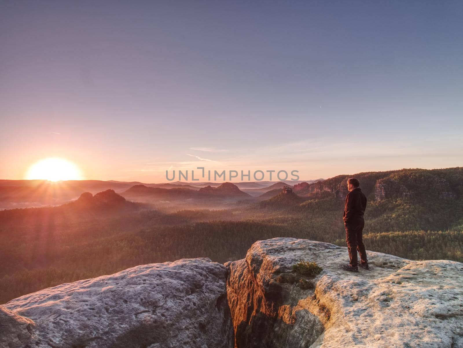 Man walking over rocky summit at rising Sun. Beautiful moment  by rdonar2