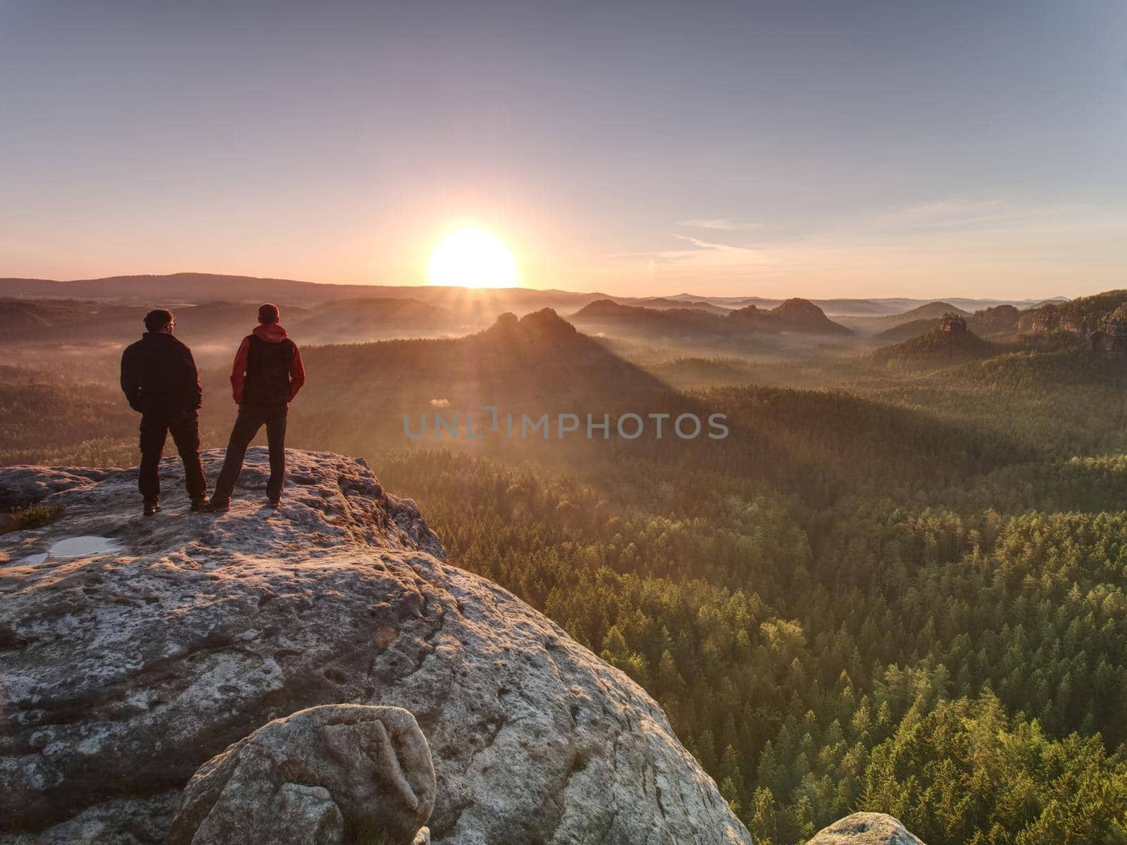 Two guys close to edge on cliff, watching awakening nature by rdonar2