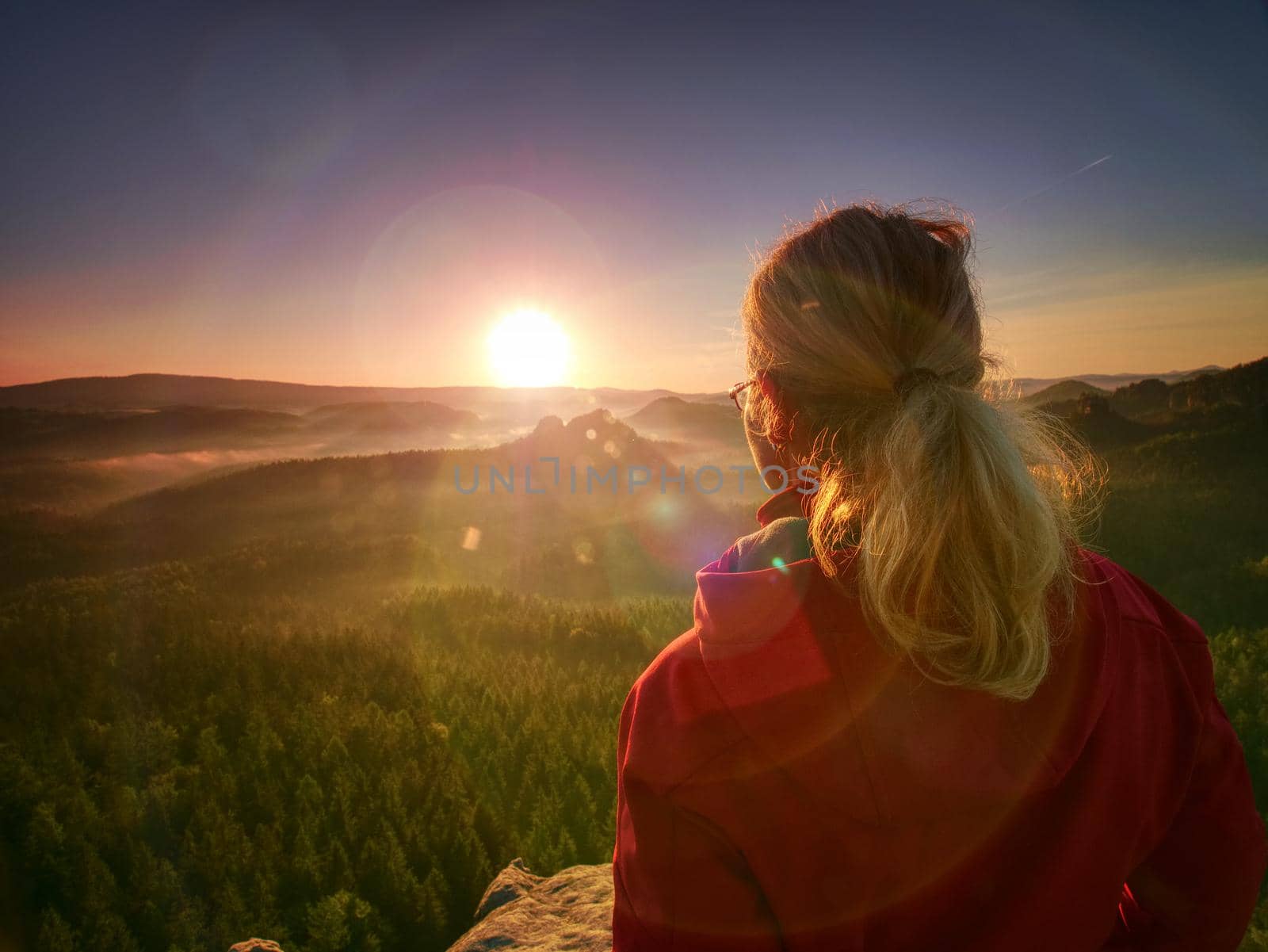 Beautiful blond hair woman looking outside. Woman head posing at the sunset, portrait of the young pretty woman