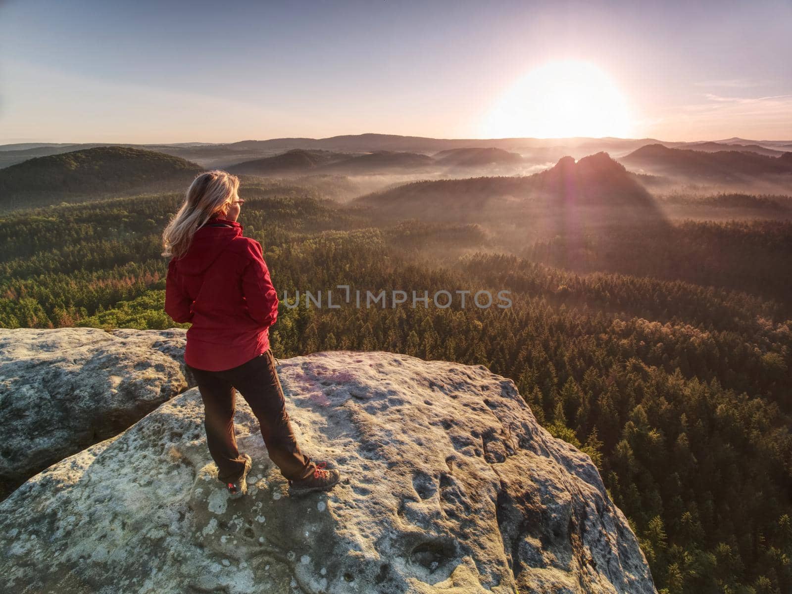 Woman in outdoor clothes  enjoy view at summit in mountains. by rdonar2