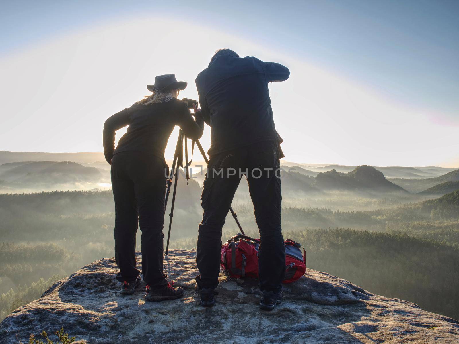 Couple tourist with photo camera at top of mountain watch sunset by rdonar2