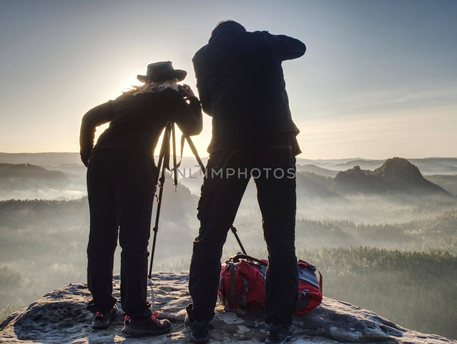 Two photographers discuss and share my experiences. Artists make amazing photos on a ledge above the daybreak pure nature.
