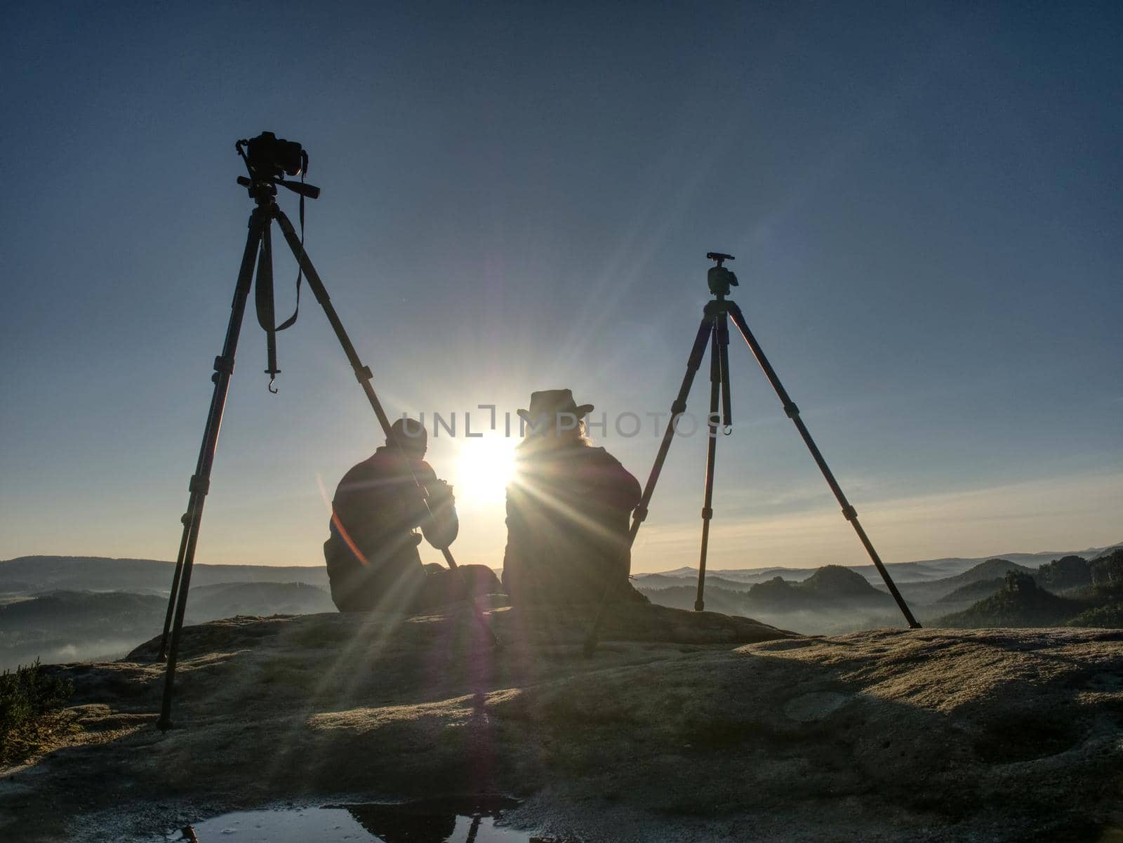 Creative artists stay at own cameras on tripods.  Hikers and enthusiasts  by rdonar2