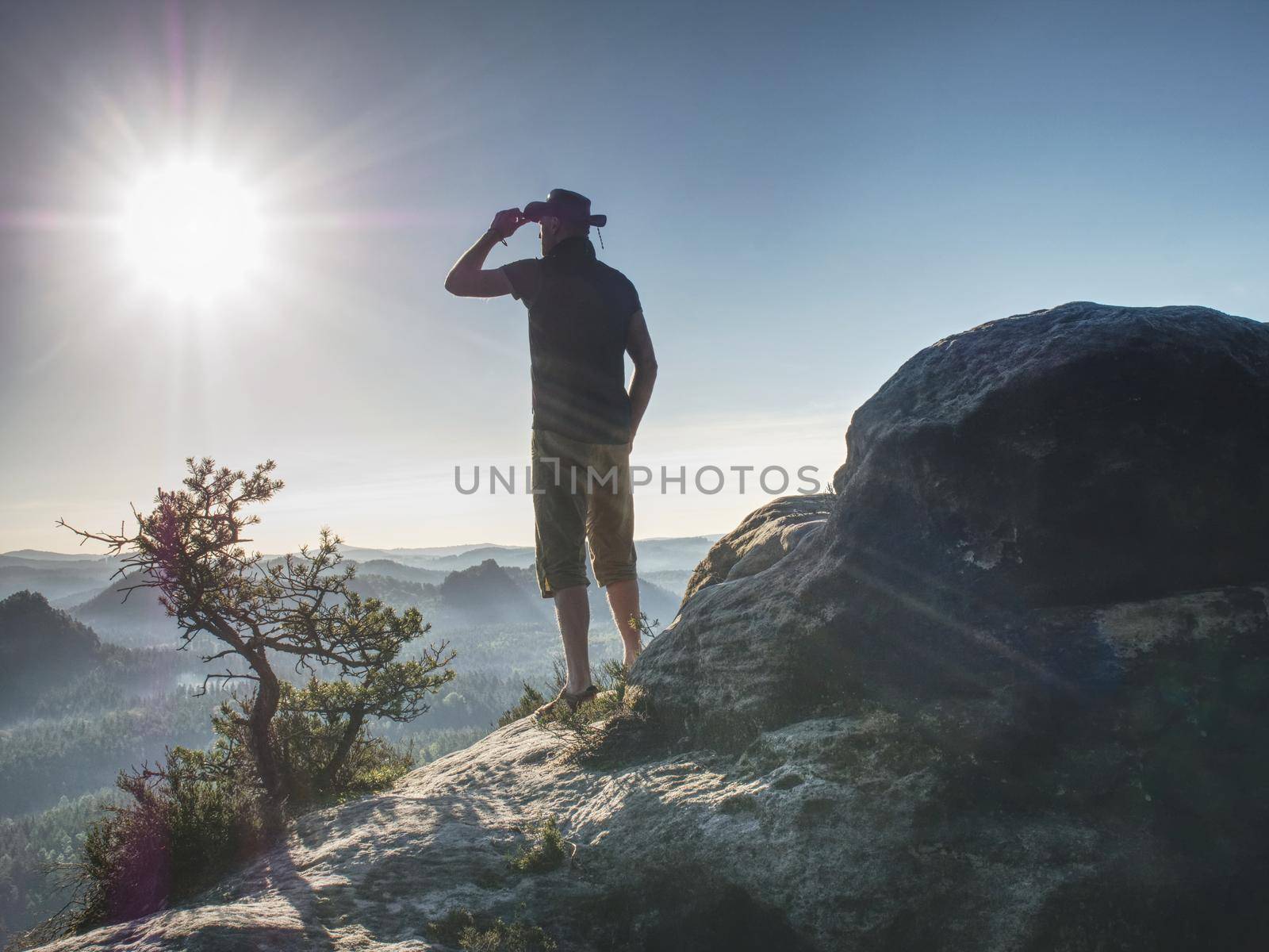 Trekker in cowboy hat enjoy view on the mountain with Beautiful Sunrise and sea of mist in the morning on Khao Luang mountain 