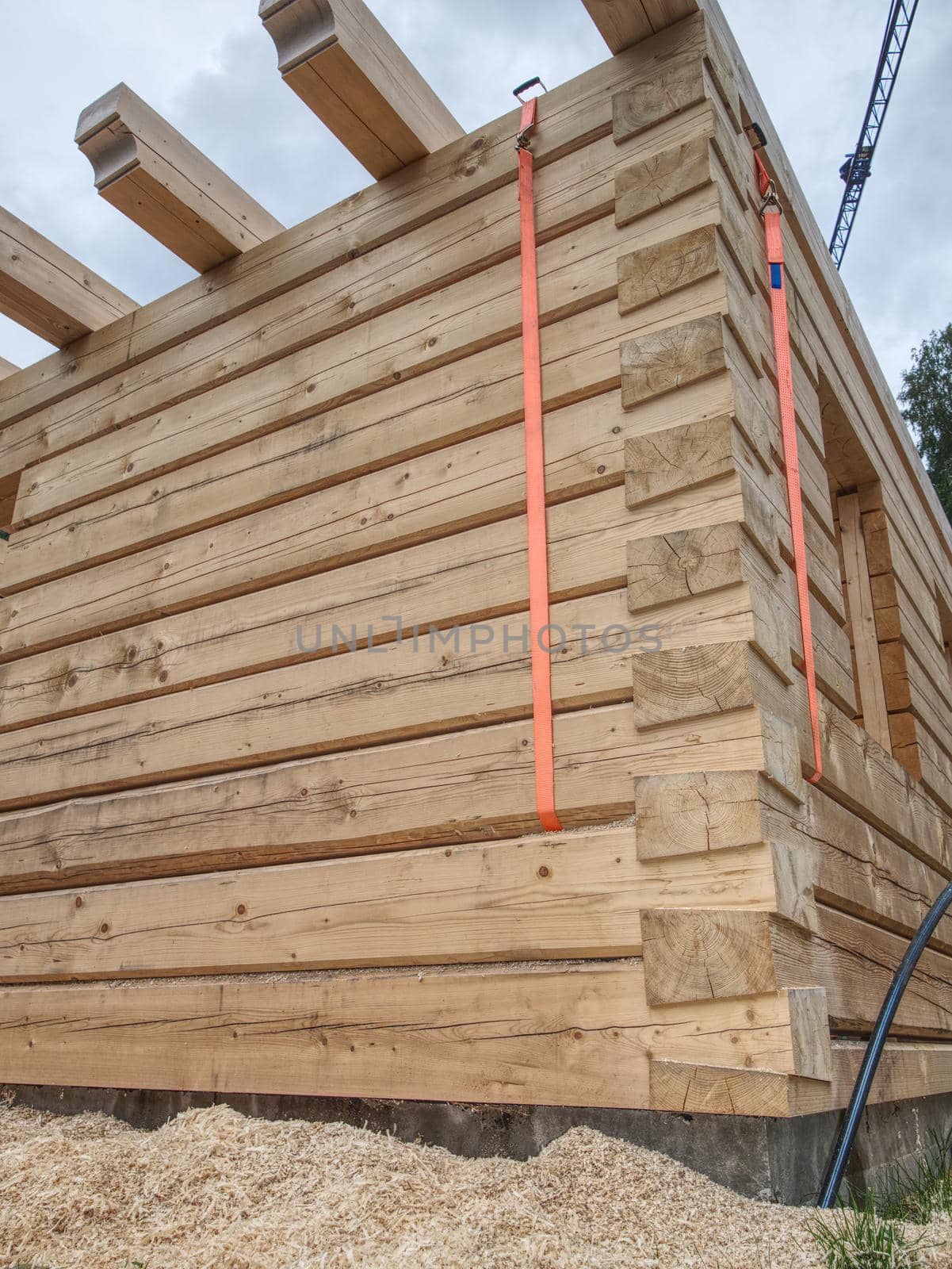 Detail of square beams in cabin wall. Not painted wood yet. Corner of a wooden house under construction.