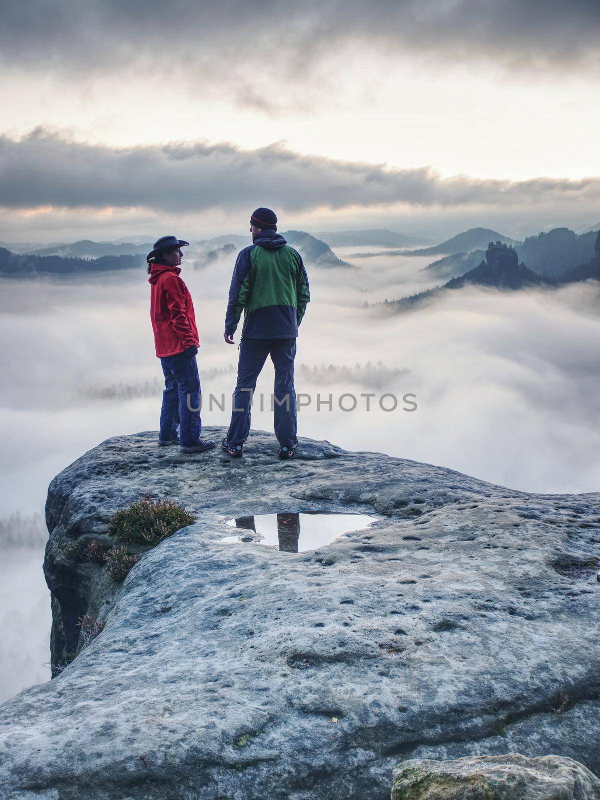 Happy couple with enjoy view after climbing top of rocky mountain.  Partners watch the beauty wild nature wood on the mountain