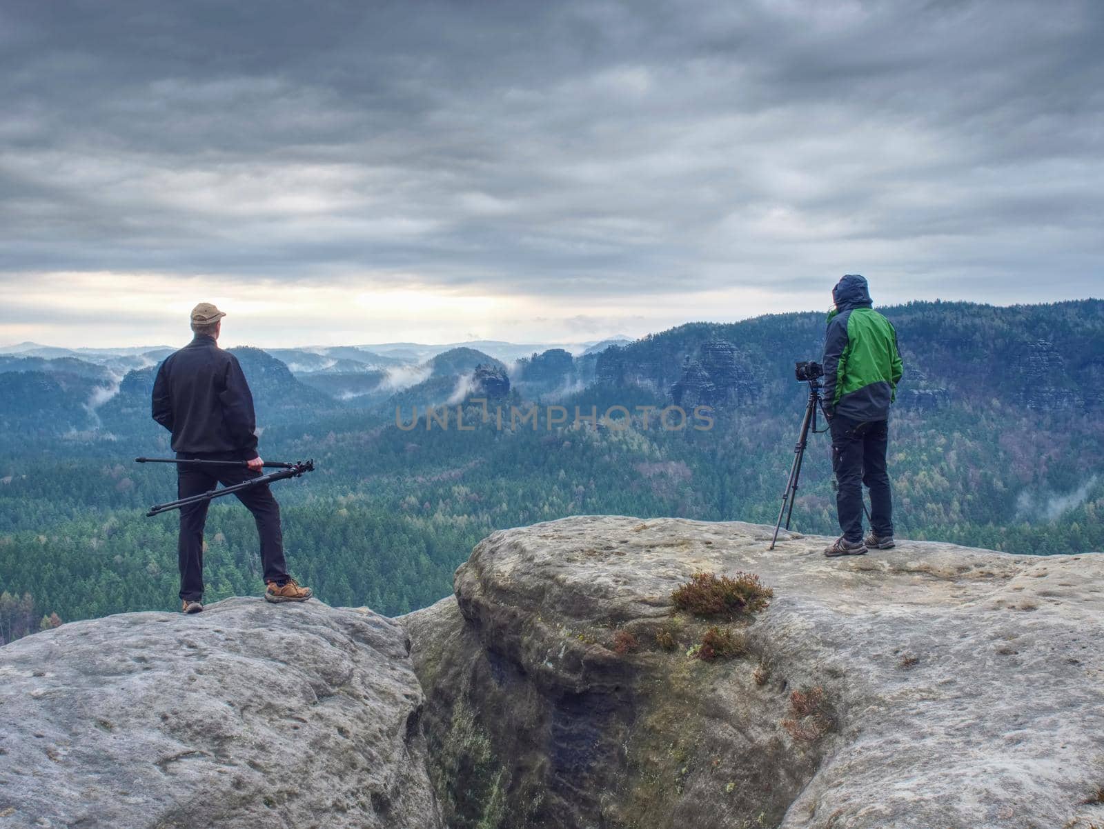 Outdoor shot of talented hobby photographers taking pictures  in rocks.  Camp, adventure, trip and traveling concept.