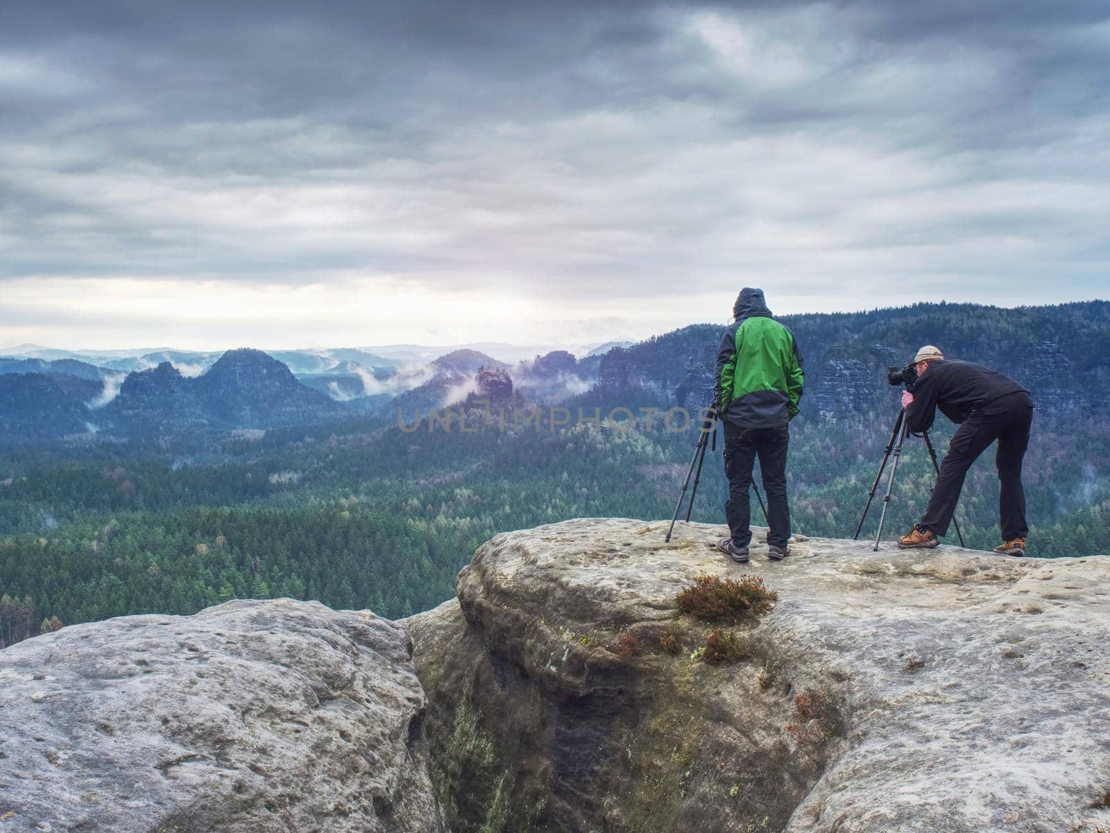 Outdoor shot of talented hobby photographers taking pictures  in rocks.  Camp, adventure, trip and traveling concept.