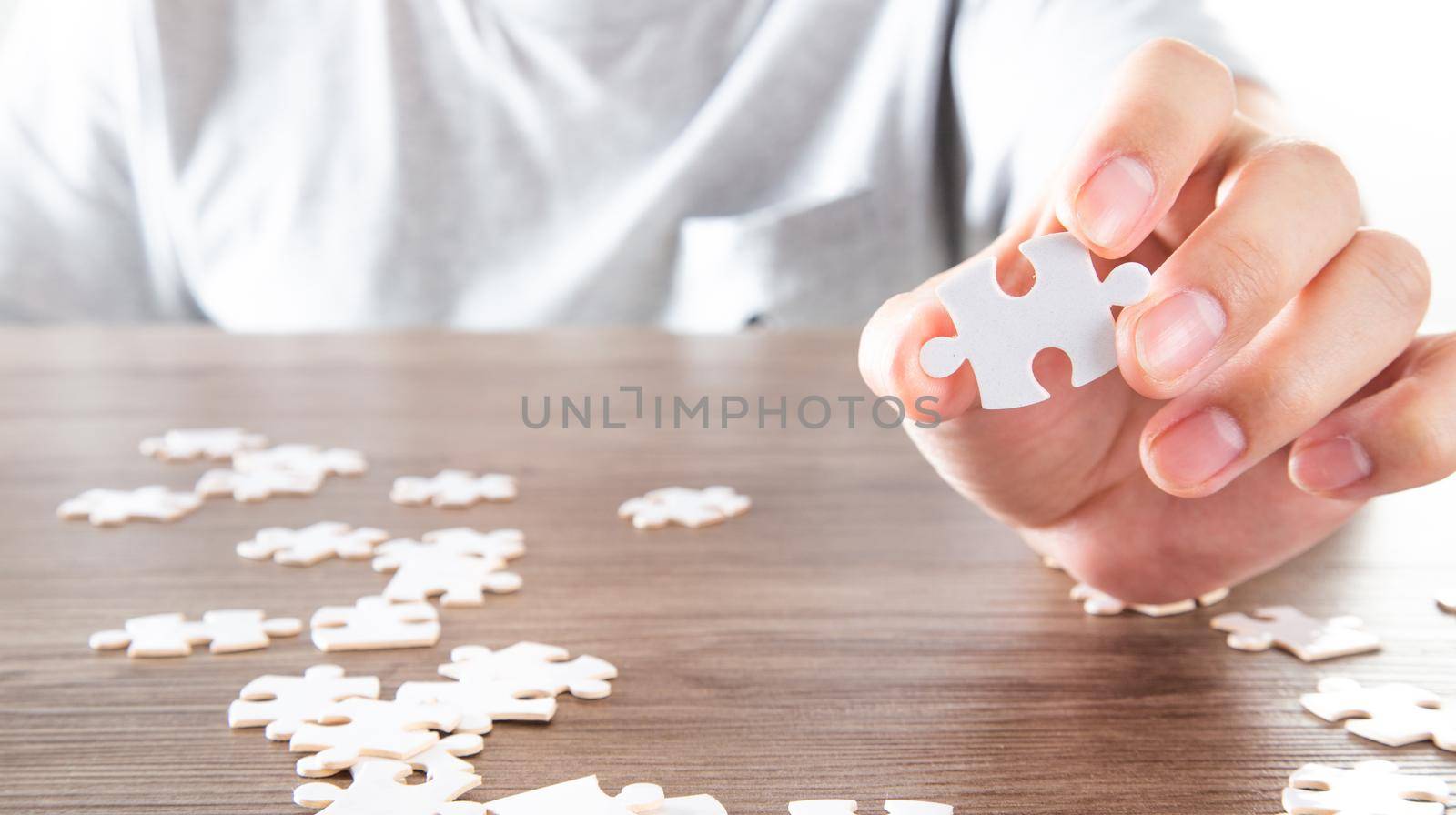 Closeup hand of man holding parts jigsaw puzzle. Business solutions, success and strategy concept