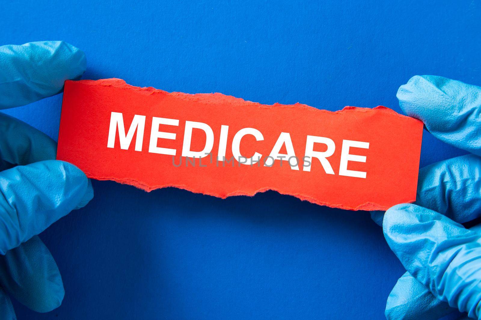 Doctor holds a red paper with the word MEDICARE, Medical Inusrance concept