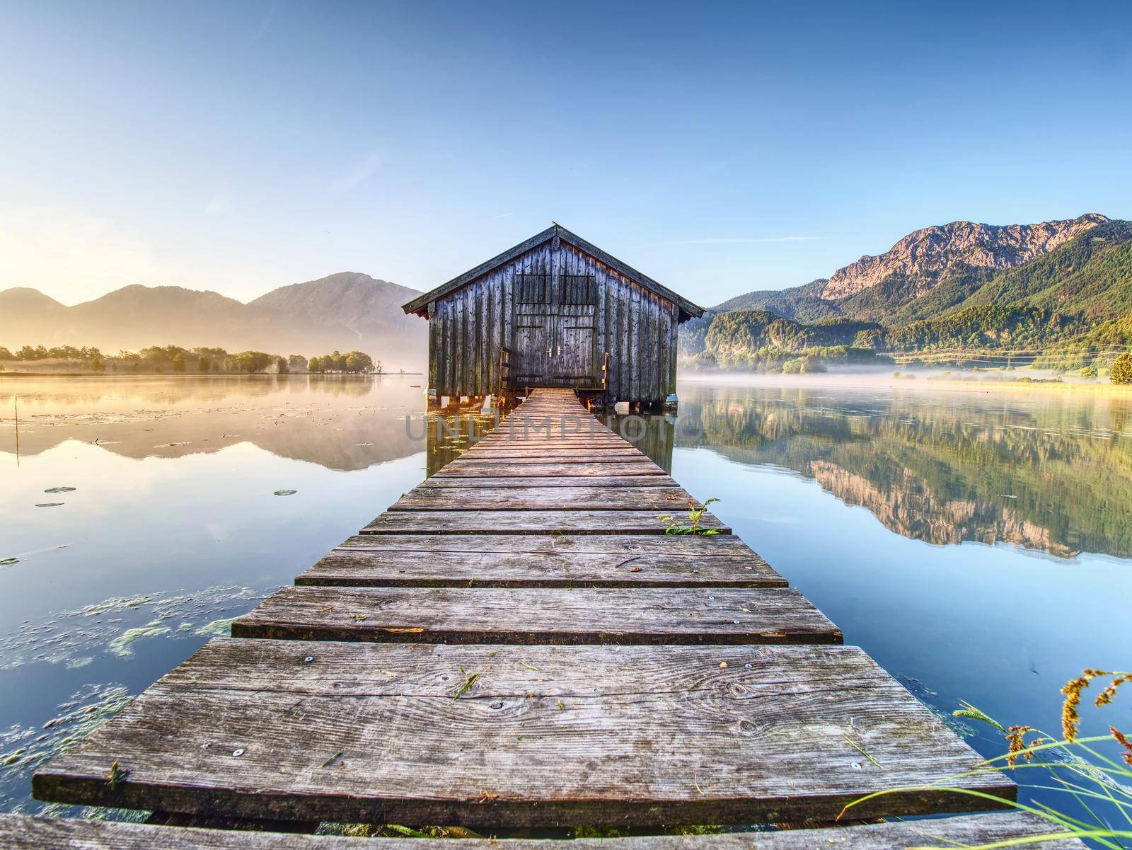 Beautiful mmorning at lake with traditional wooden boat house. Shore of famous mountain ake Nationalpark, Germany 