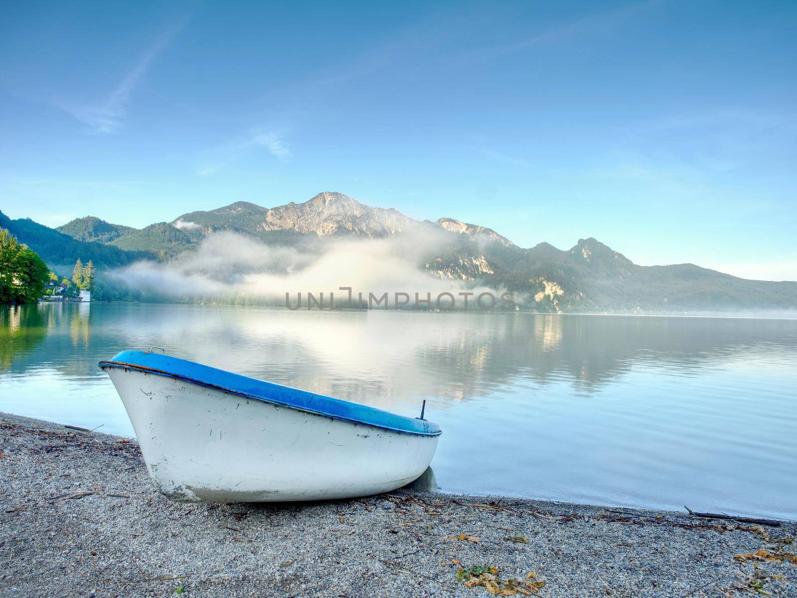 Fishing boat on shore on background of picturesque landscape by rdonar2