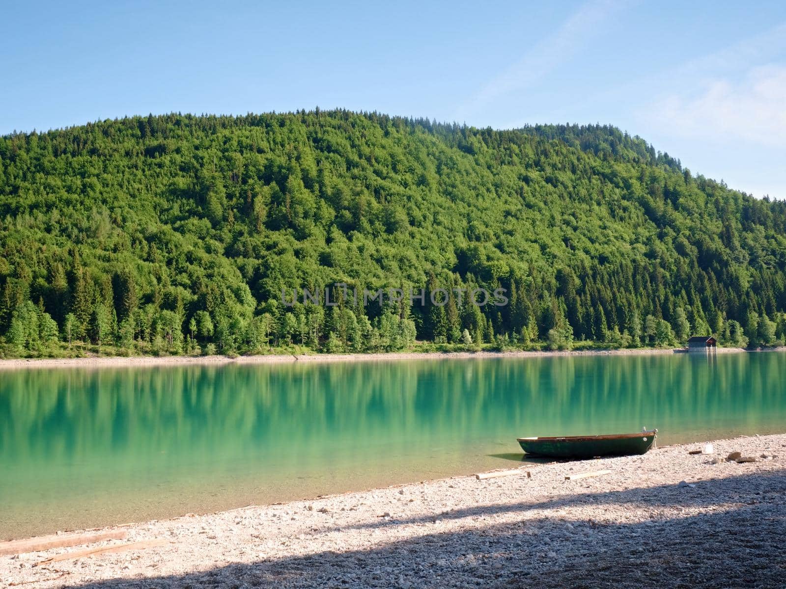 Boat anchored on bank of lake. Mountains in water  level by rdonar2