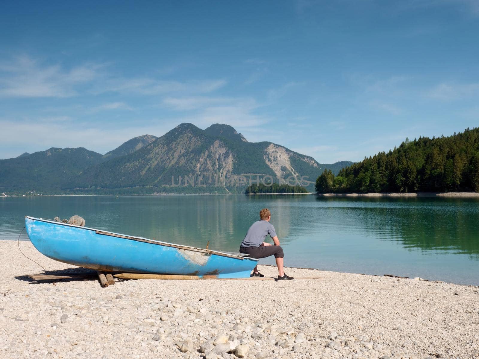 Sports boats, blue green mountain lake, windless summer day. 