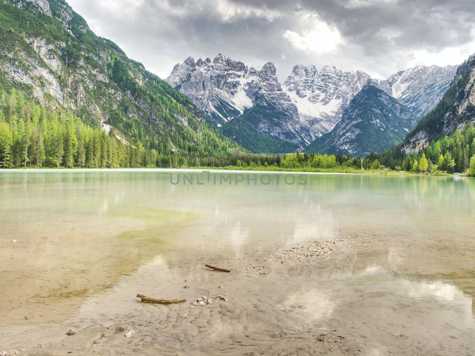 Blue green lake between sharp rocky mountains.  Smooth water surface,  by rdonar2