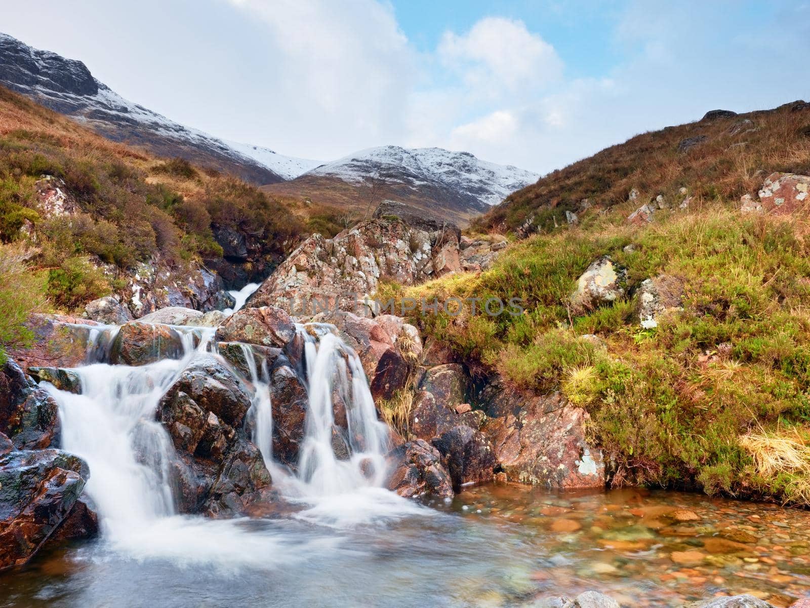 Rapids in small waterfall on stream, Higland in Scotland an early spring day. Snowy mountain peaks by rdonar2