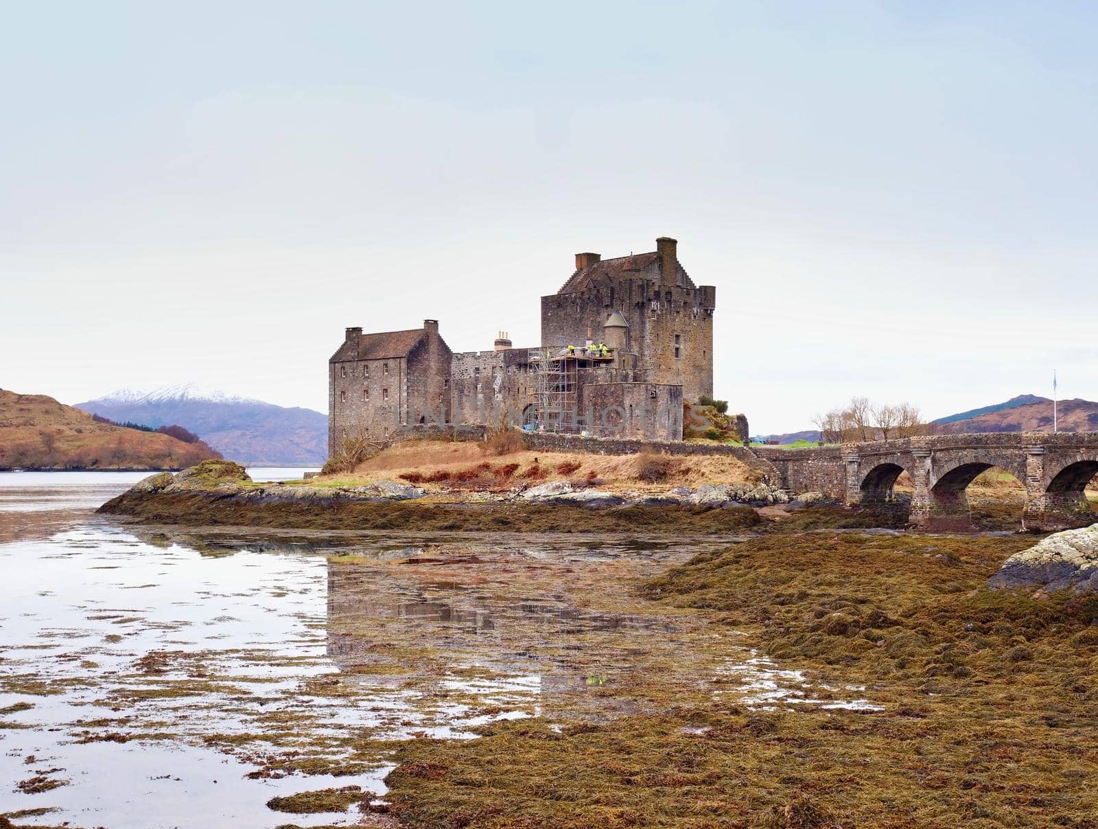 Eilean Donan Castle with a stone bridge above the water,  Scotland,  It was destroyed during the Jacobite rebellions in the early 18th century, and rebuilt