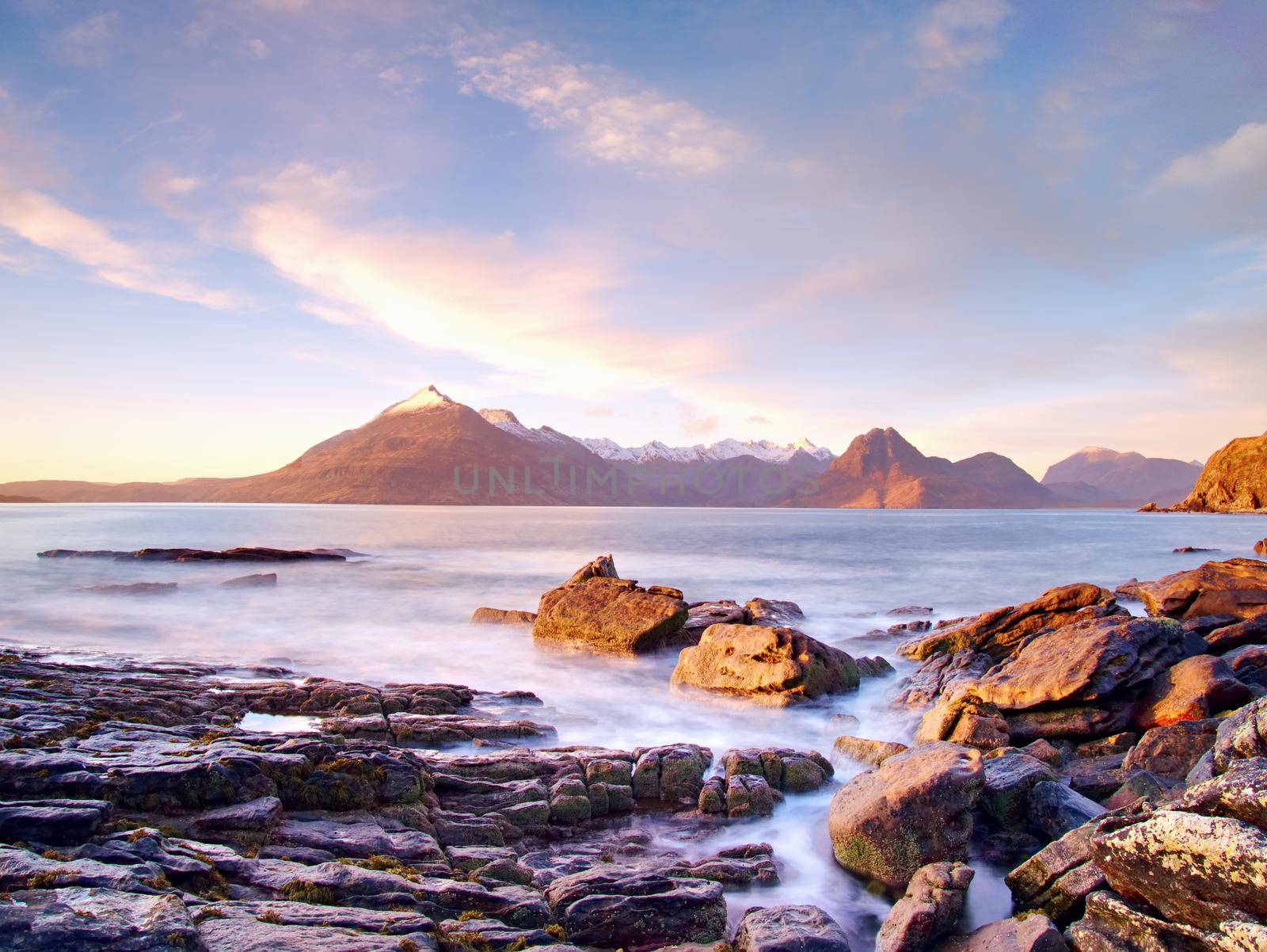 Evening at Loch Scavaig with Cuillins mountains in warm sunset light.  Isle of Skye Scotland