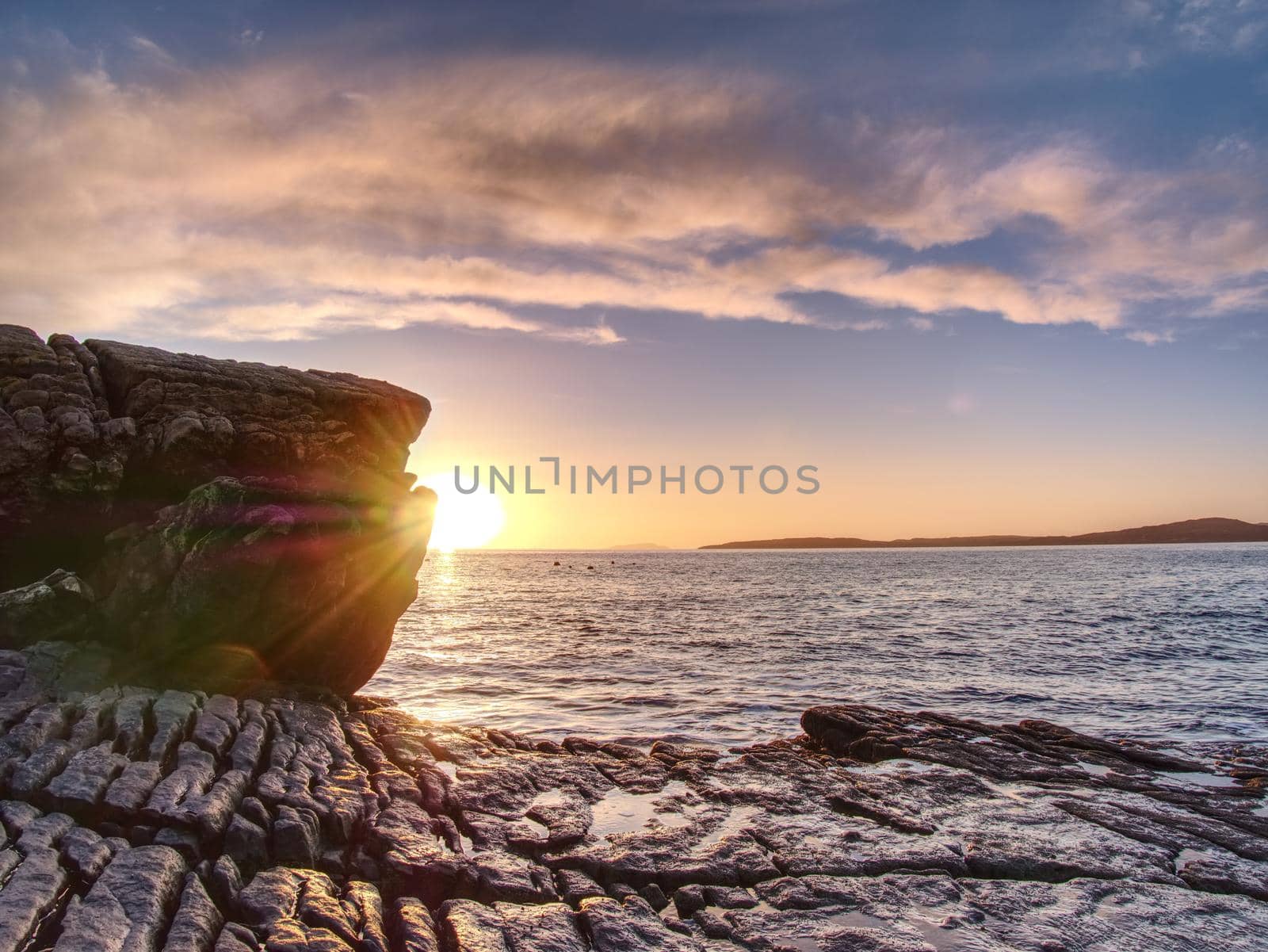 Rocky coastline in Elgol at sunset with cracked rocks in detail, Isle of Skye, Scotland. Blue shadows  by rdonar2