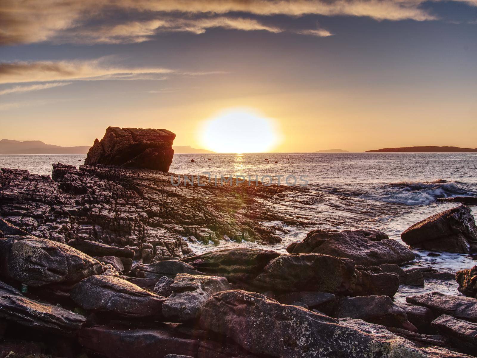 Peaceful dawn at Elgol bay. Low angle  overlooking of offshore rocks and smooth sea, mountains  by rdonar2