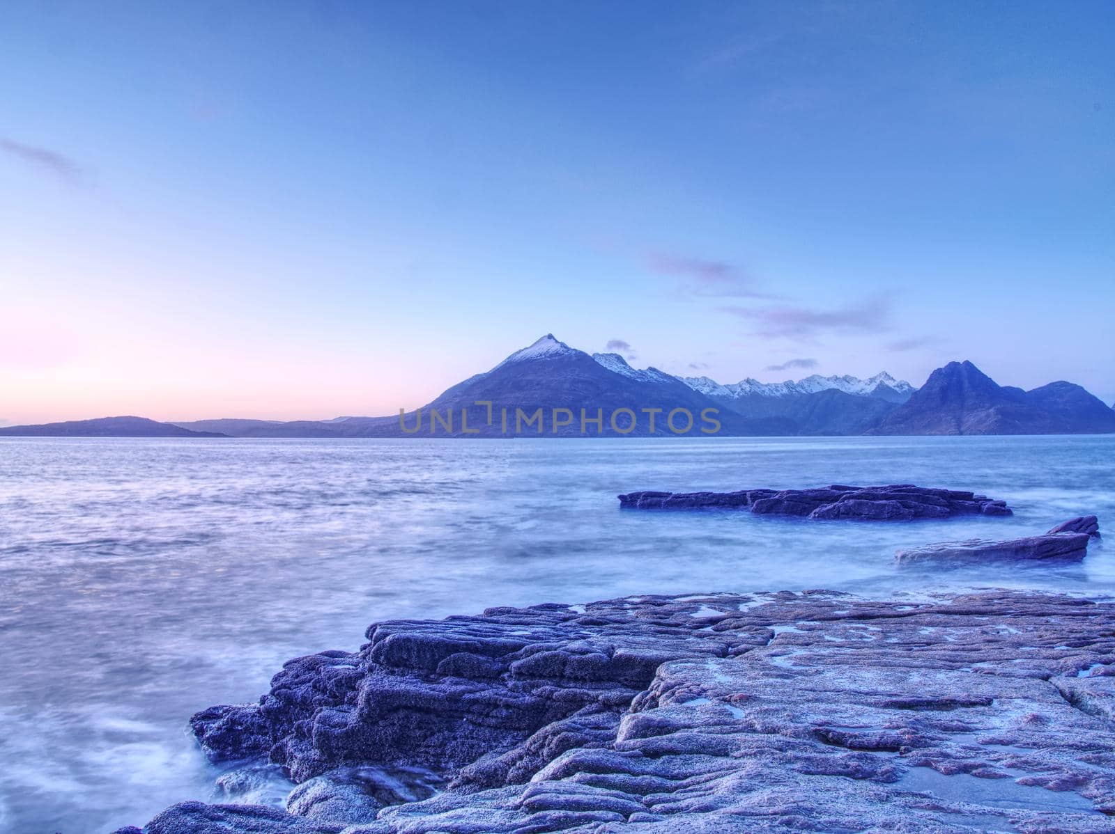 Rocky coastline in Elgol at sunset with cracked rocks in detail, Isle of Skye, Scotland. Blue shadows  by rdonar2