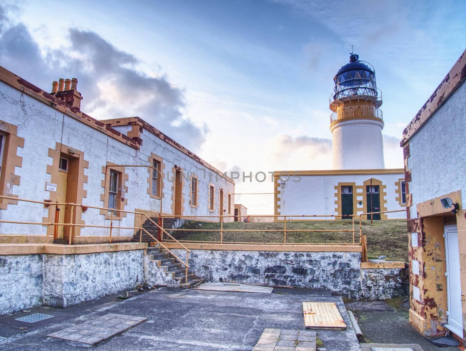 Old lighthouse on Neist Point, abandoned  building with tower against to evening sky. Popular Neist Point.