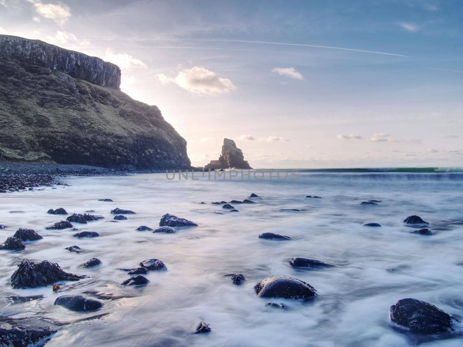 Sea stack silhouette by sunset sky. Evening light on the rocks,  by rdonar2