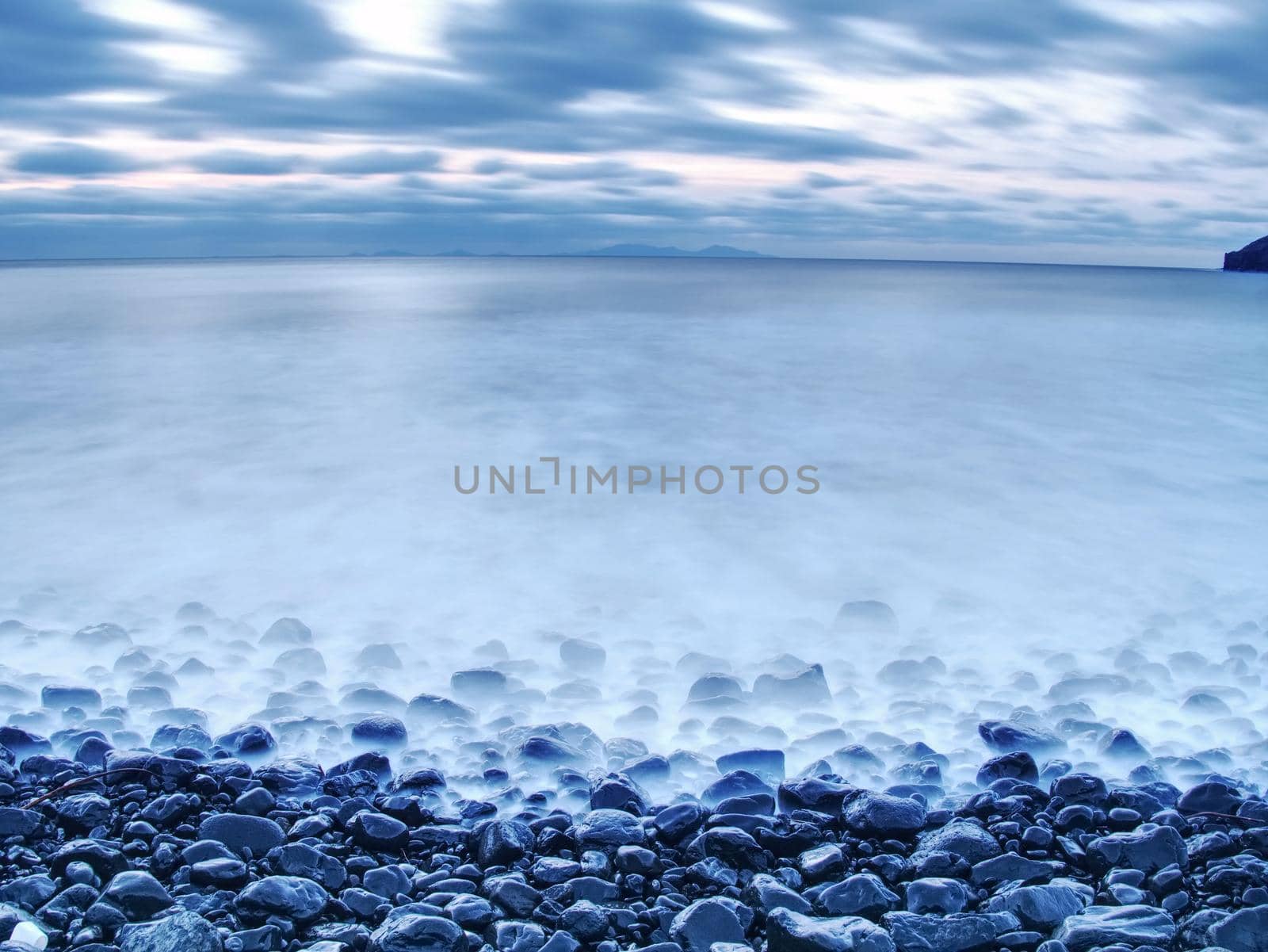 Blue sunset at rocky coast of sea. Slow shutter speed by rdonar2