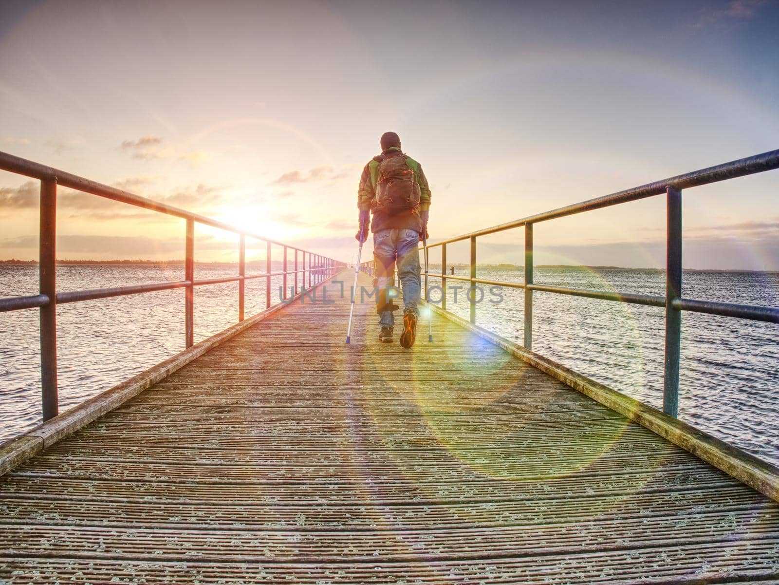 Traveler on wooden pier or jetty waiting for ferry boat.  by rdonar2