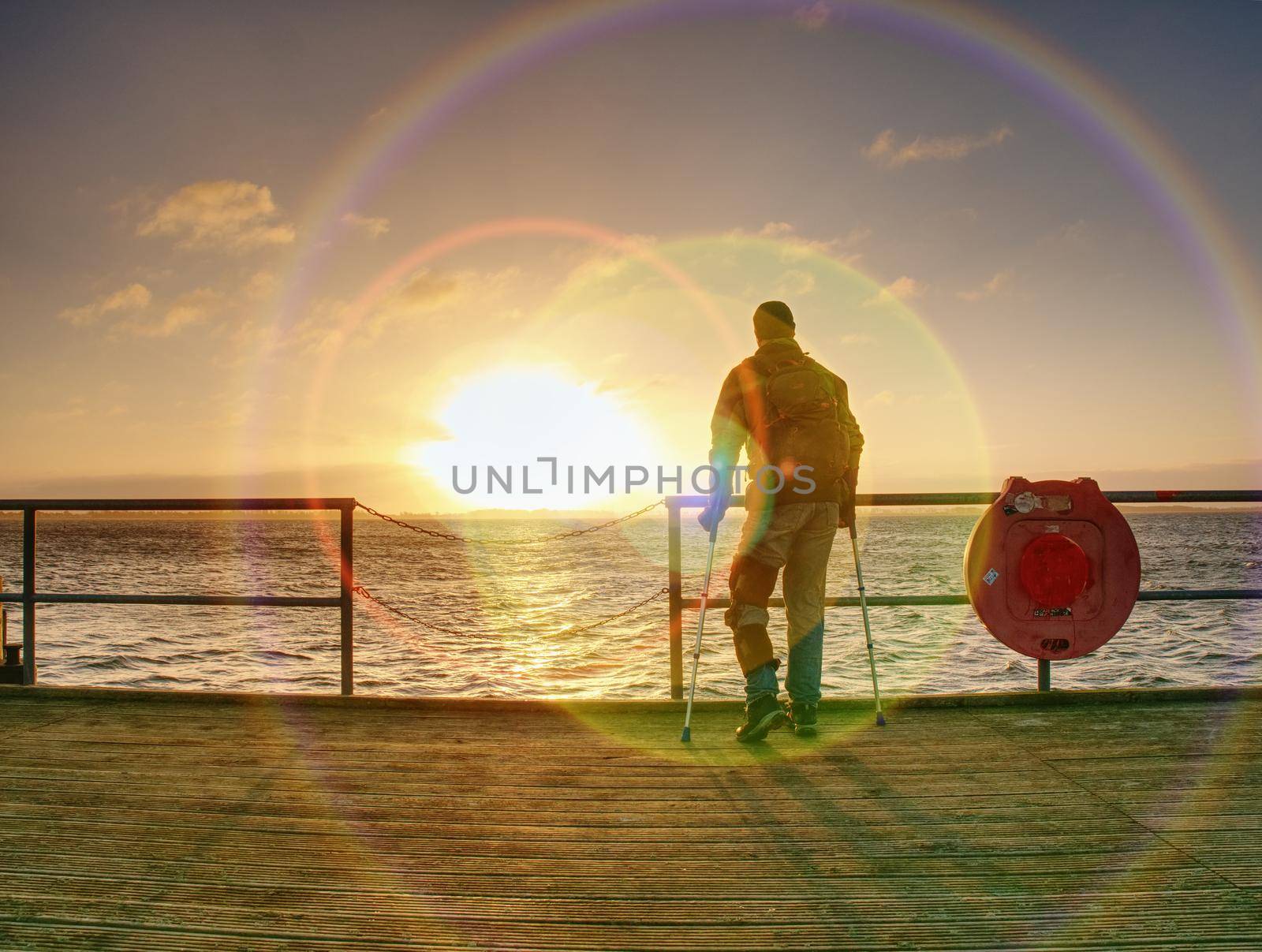 Man at the end of pier wait for ferry.  by rdonar2