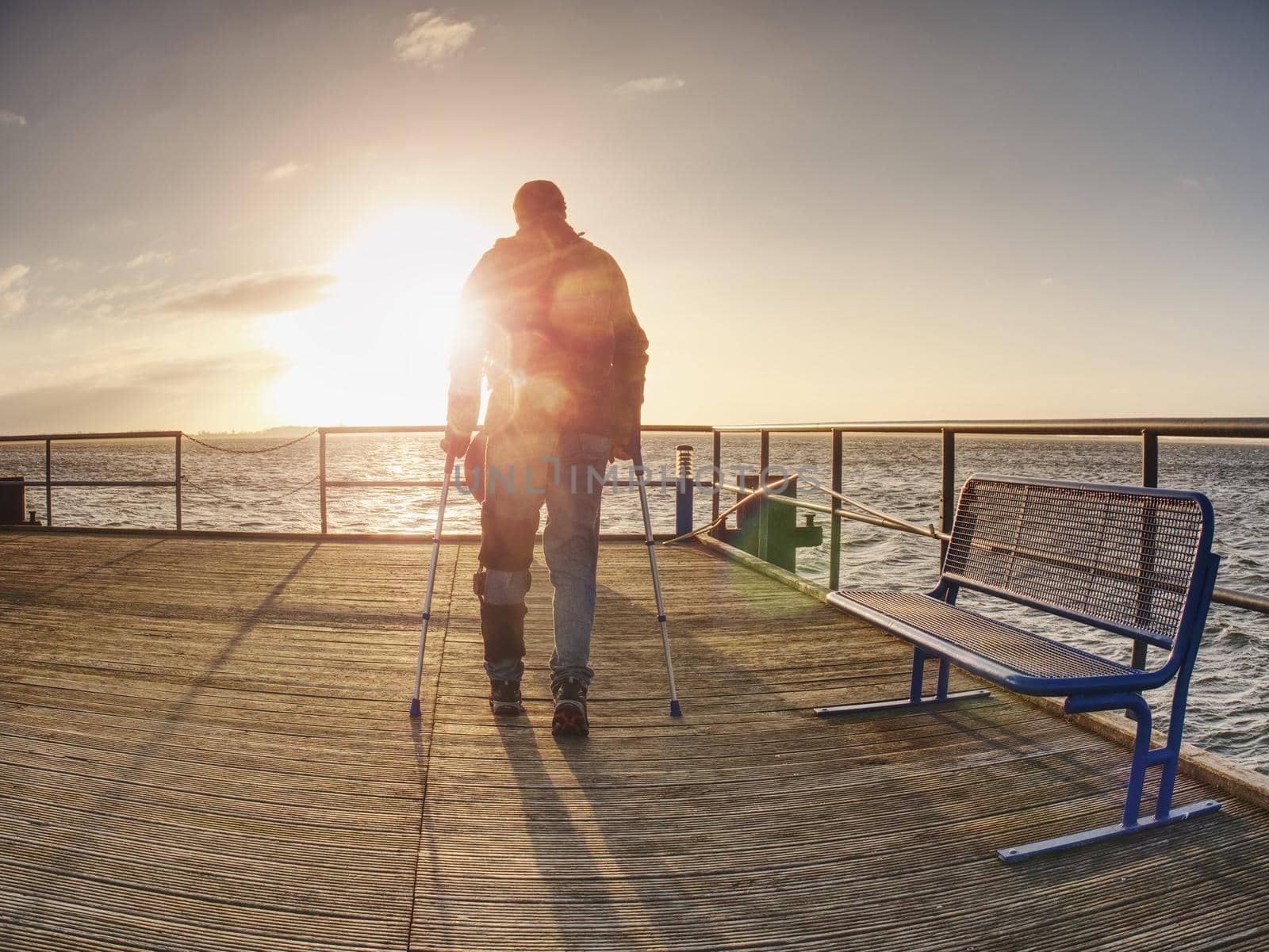 Traveler on wooden pier or jetty waiting for ferry boat.  by rdonar2