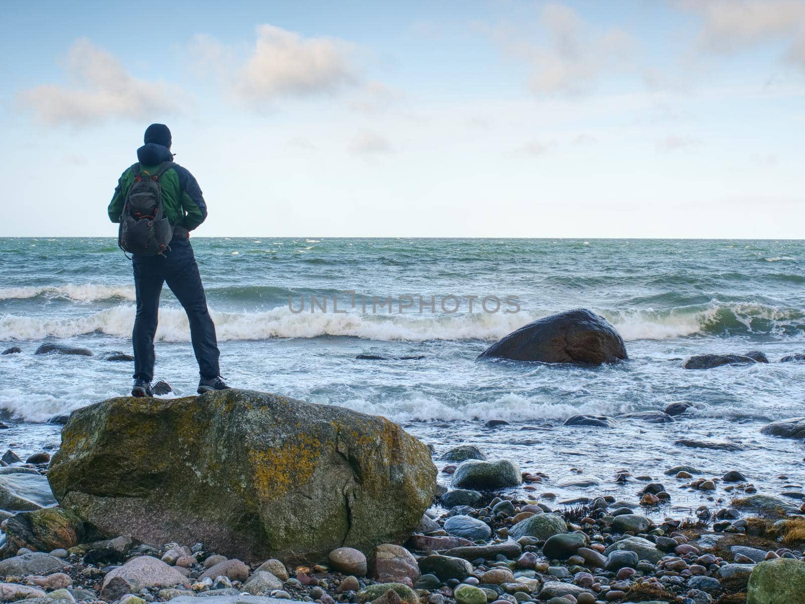 Man standing on rock in the middle of ocean.  Tourist stand alone  by rdonar2