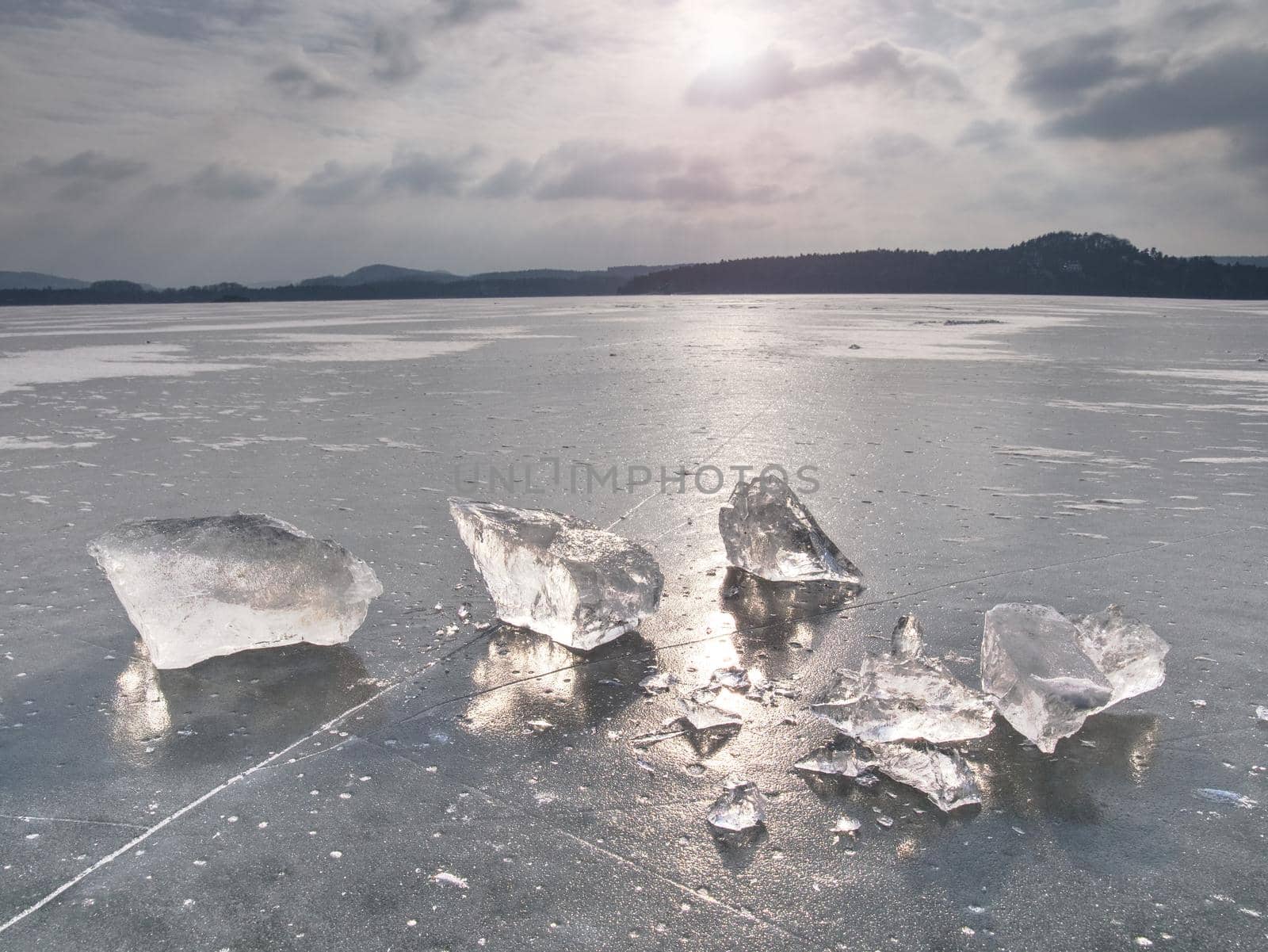 Ice covered  the lake. Big cracks in the ice floe and reflection of Sun by rdonar2