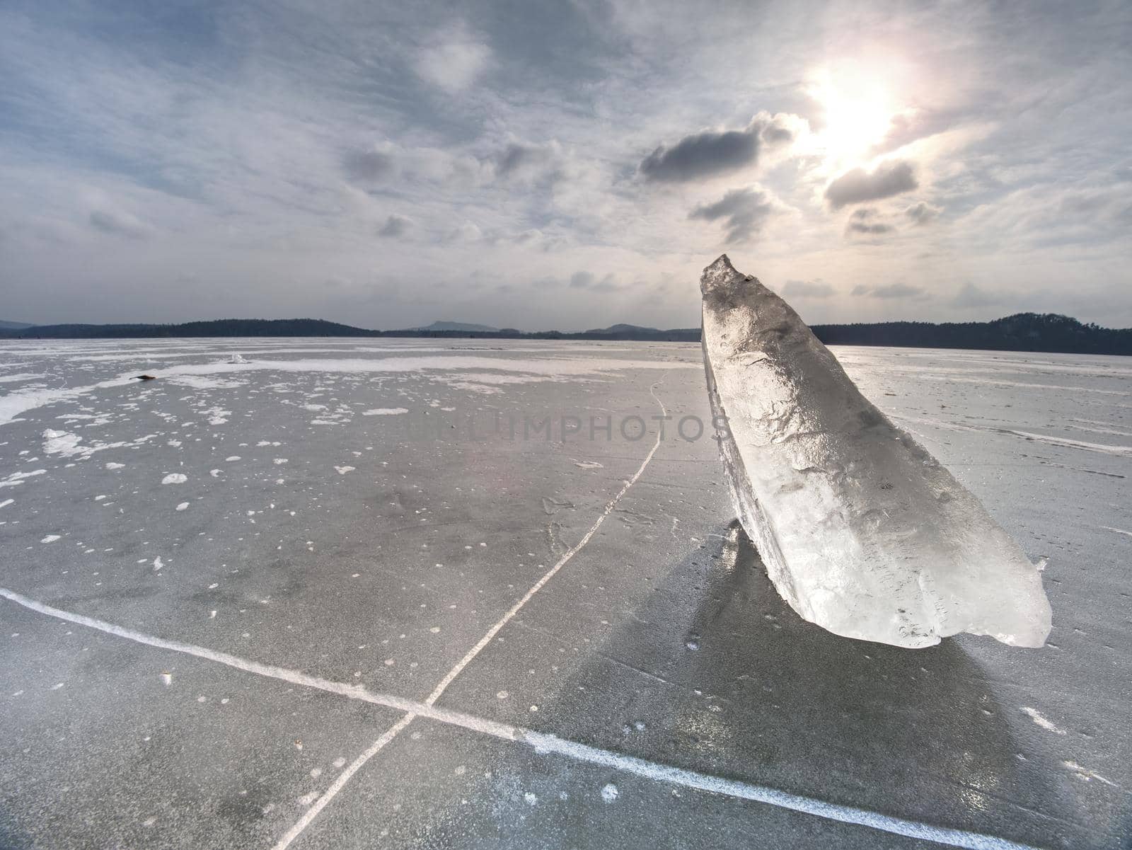 Broken piece of ice with sharp cracks inside.   Abstract ice floe. Nature background. Arctic ice.