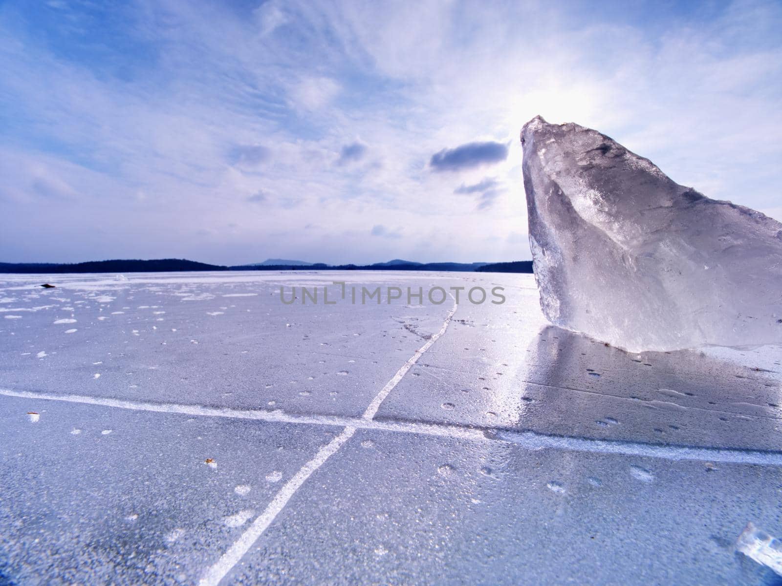 Ice breaking in pure nature. View over frozen water lake with sunset  by rdonar2