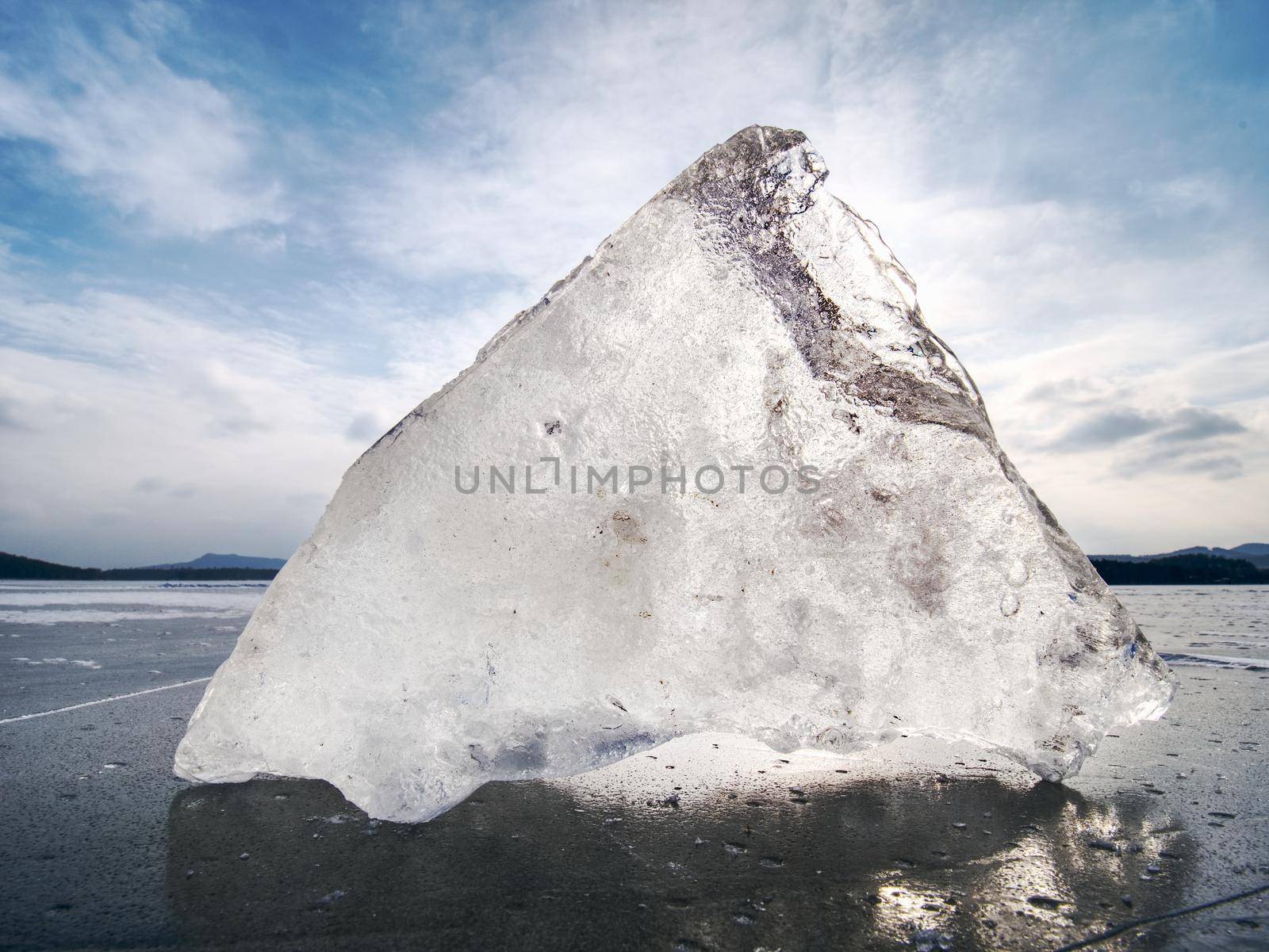 Shining broken ice. Abstract still life of ice floes. Wind, temperature differences, frost and sun in the ice crust cause cracks and ice hummocks to nice form