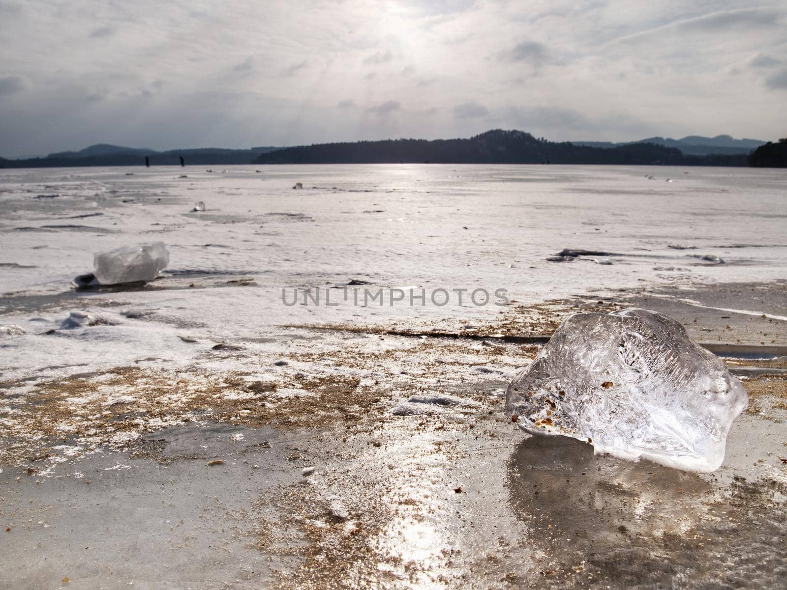 Ice breaking in pure nature. View over frozen water lake with sunset sky background,  winter natura landscape