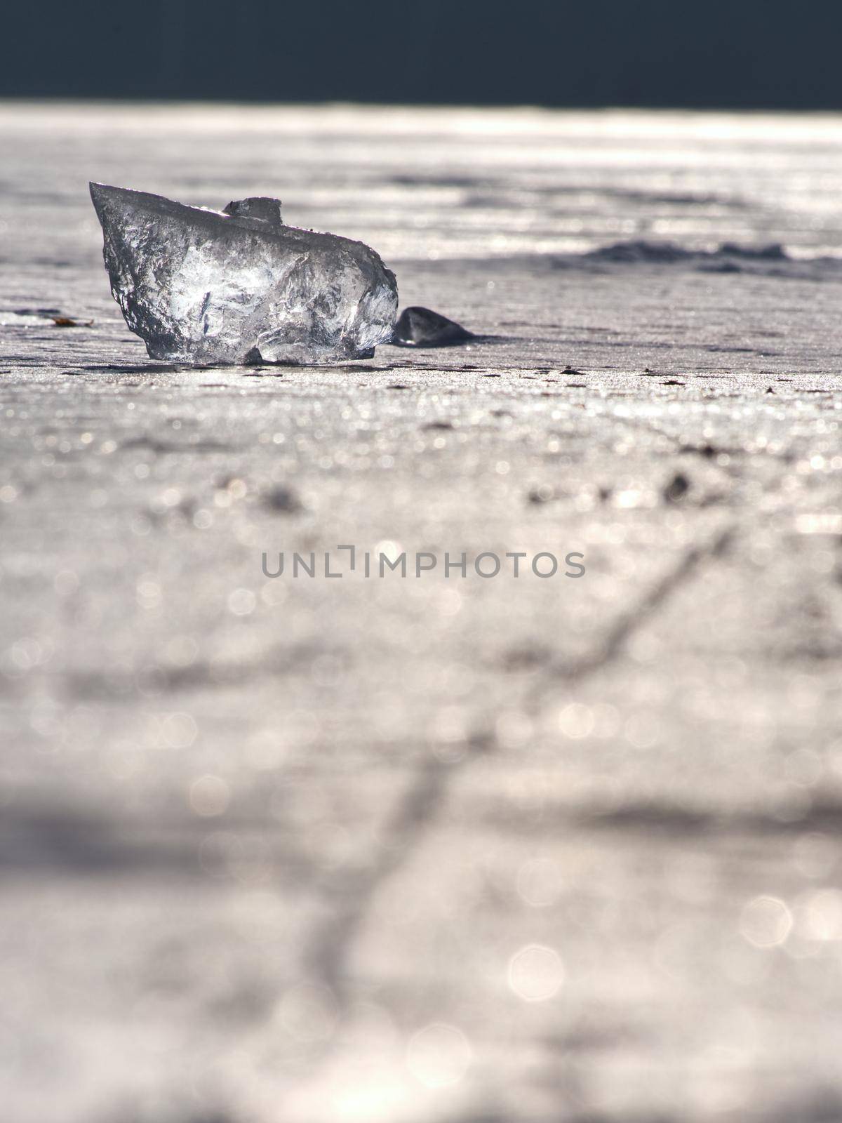 Abstract ice floe on frozen lake. Weathered ice and sparkling of sun rays.  by rdonar2
